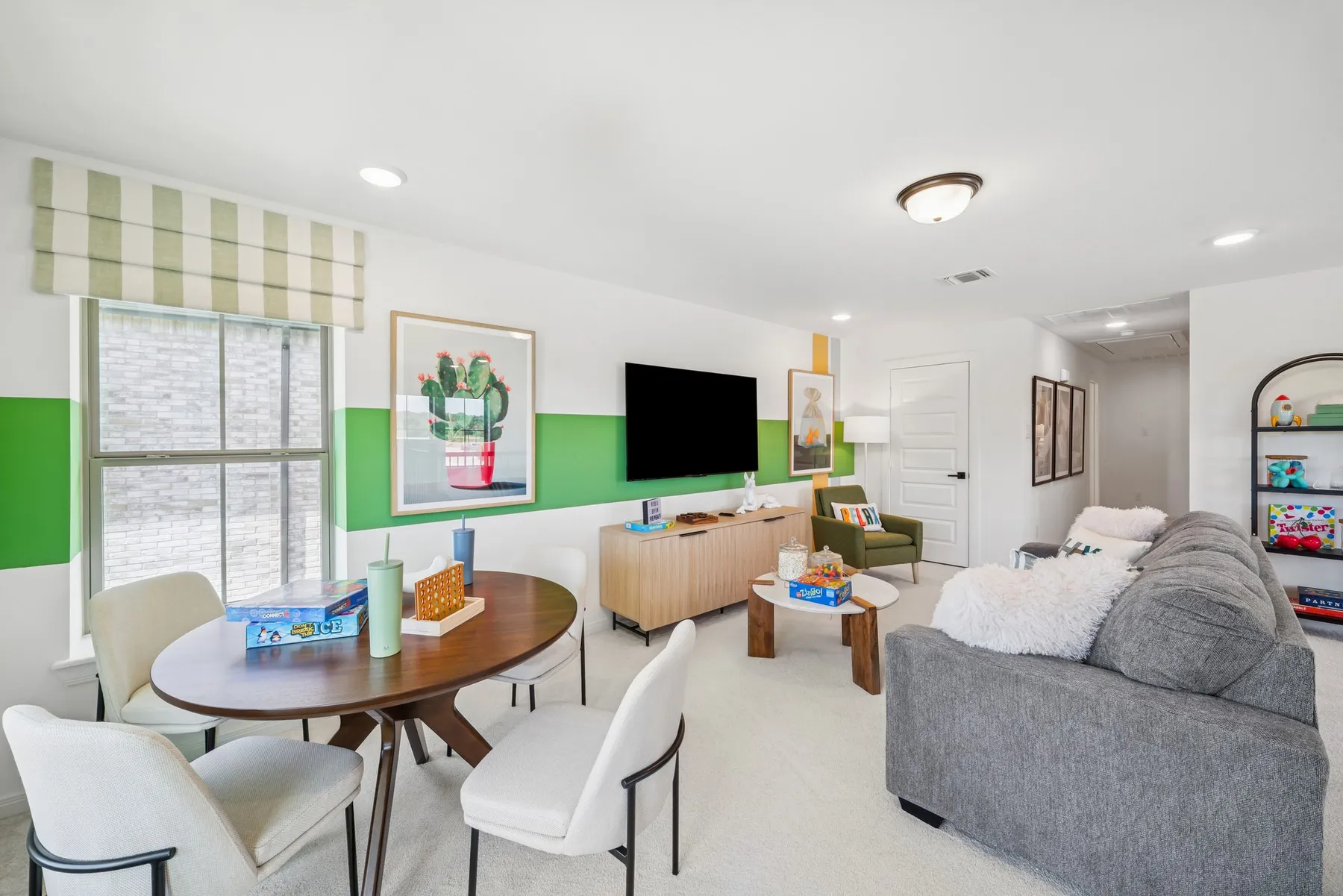 Spacious room featuring light-colored carpeting, recessed lighting, a multi-pane window with a striped shade, and a flush-mount ceiling light fixture