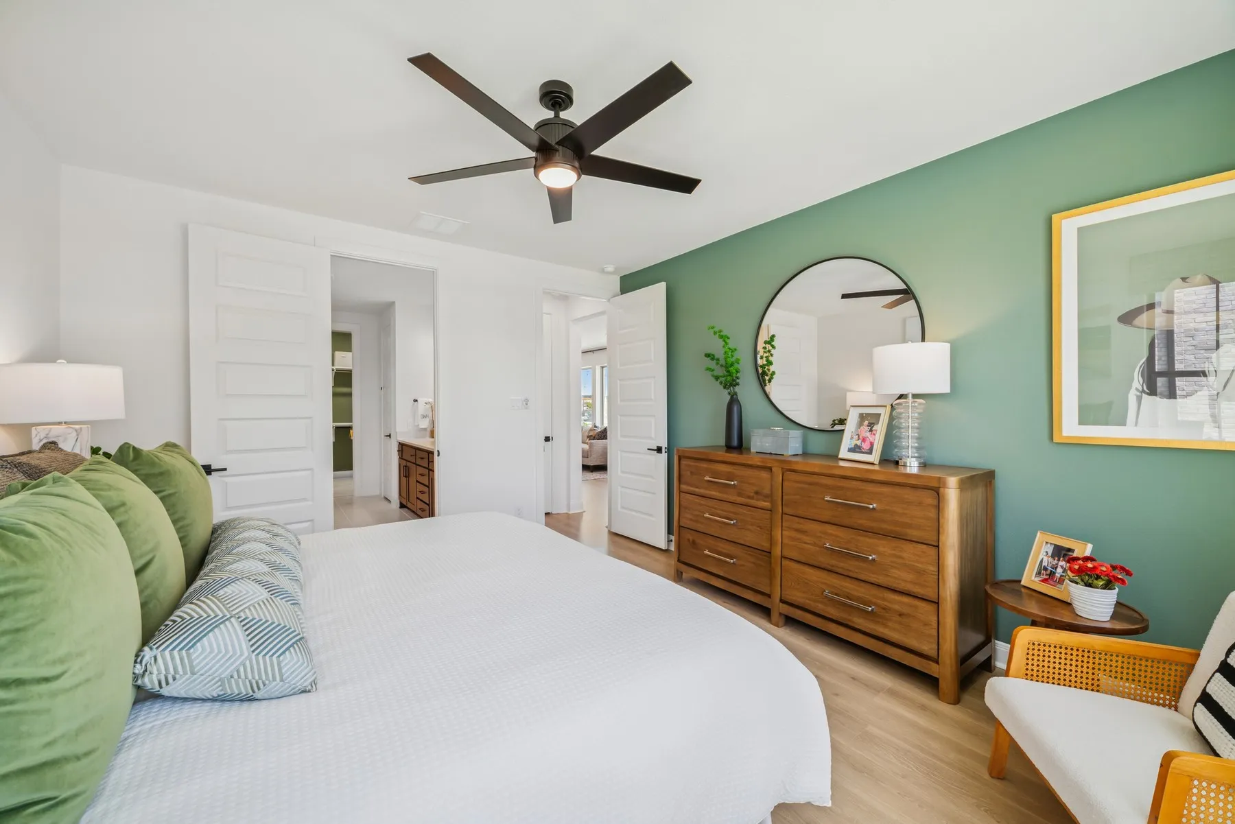 Bedroom featuring a statement green accent wall and wood-finish flooring