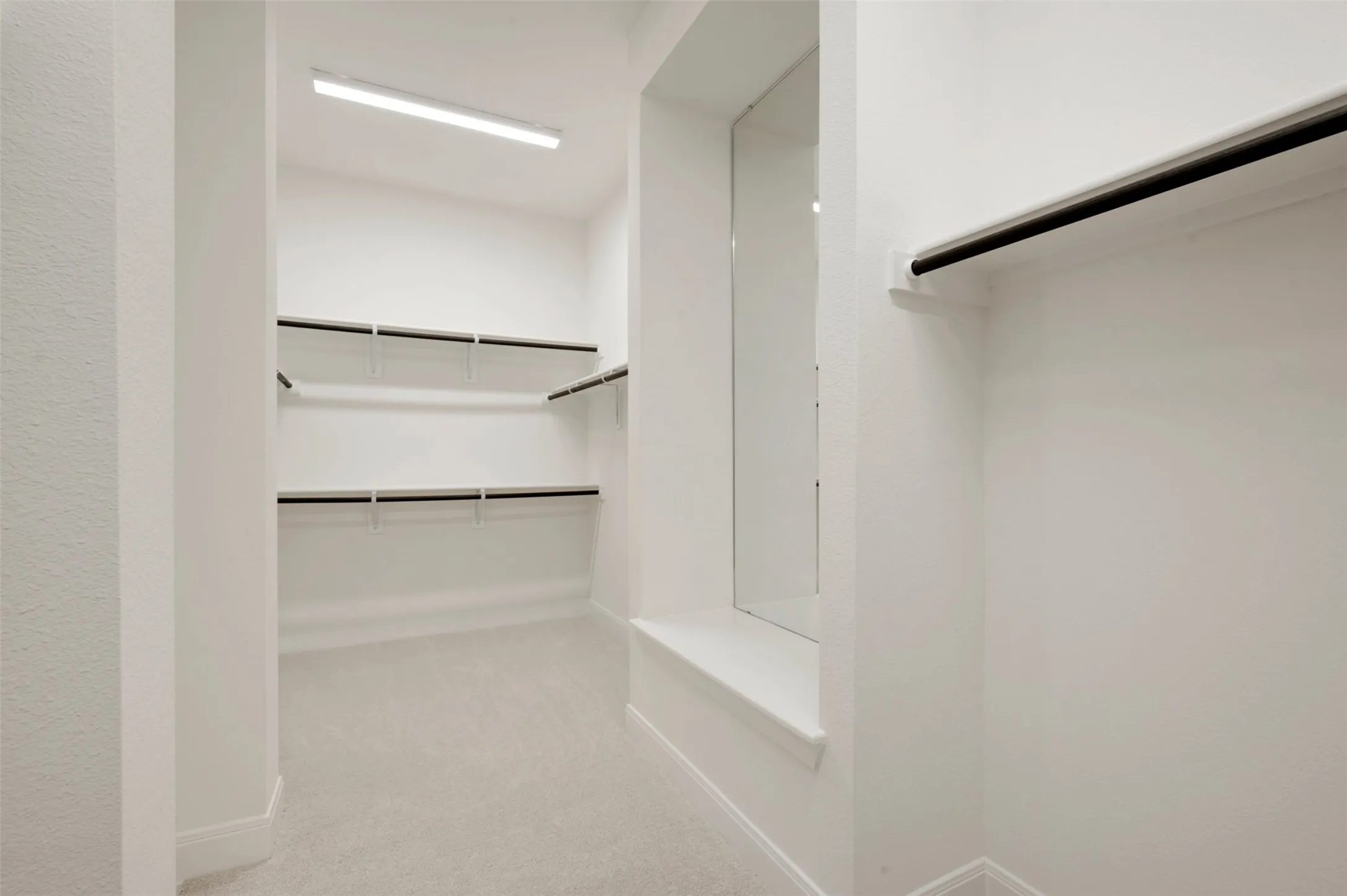 Expansive walk-in closet featuring built-in shelving, hanging rods, carpet flooring, and integrated ceiling lighting