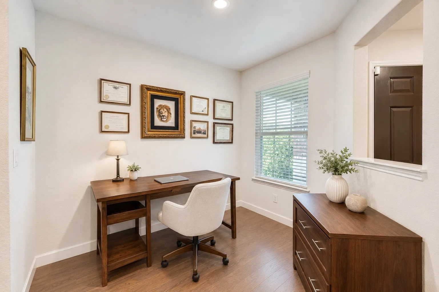 Dedicated interior space featuring wood-finish flooring, white walls, and a large window with blinds