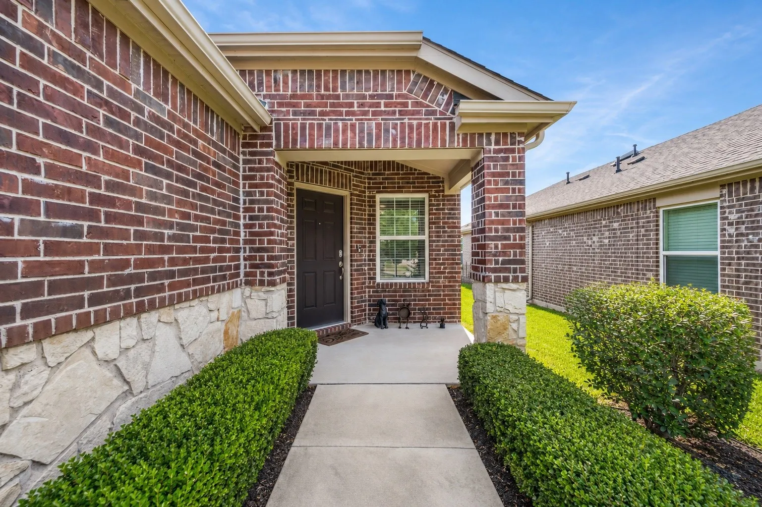 Brick exterior with stone accents and a covered entryway