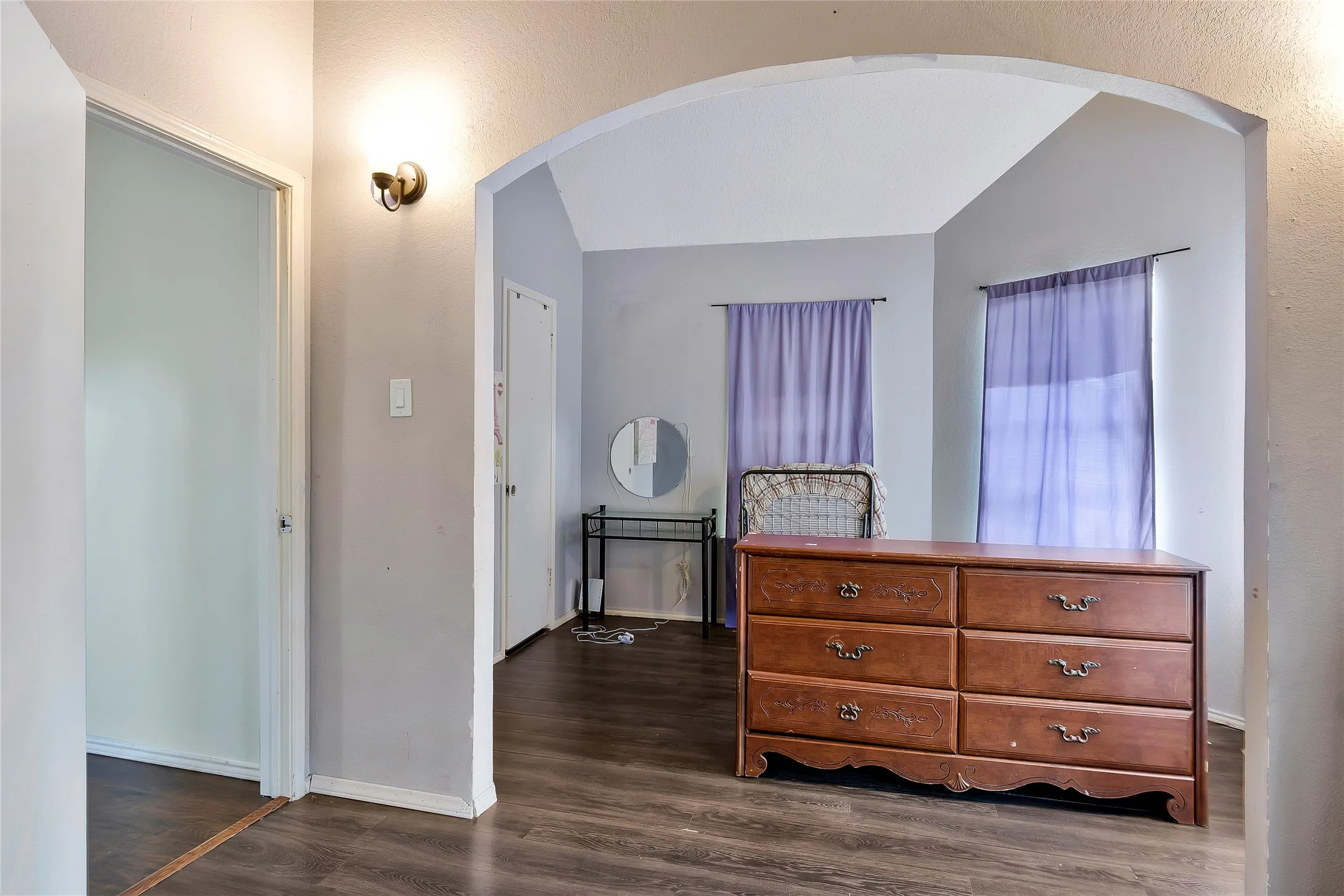 Bedroom with vaulted ceiling and dark hardwood / wood-style flooring