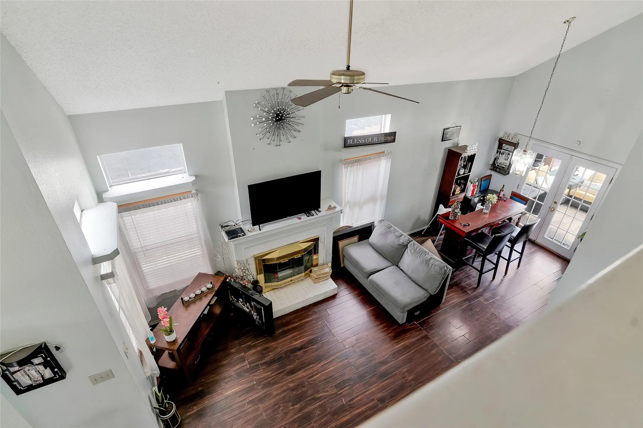 Living room with ceiling fan, a wealth of natural light, and high vaulted ceiling