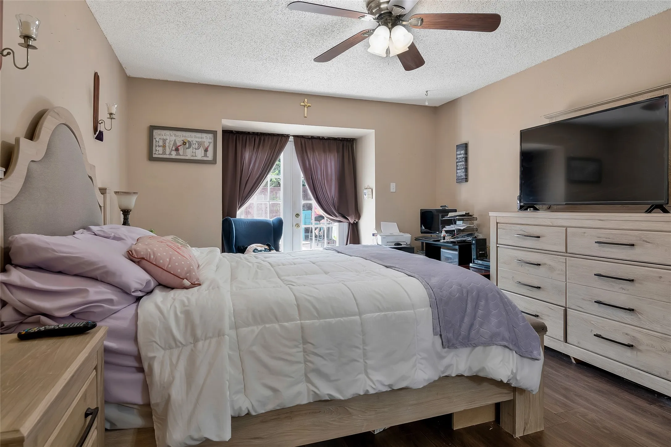 Bedroom featuring a textured ceiling, ceiling fan, access to exterior, and dark wood-type flooring