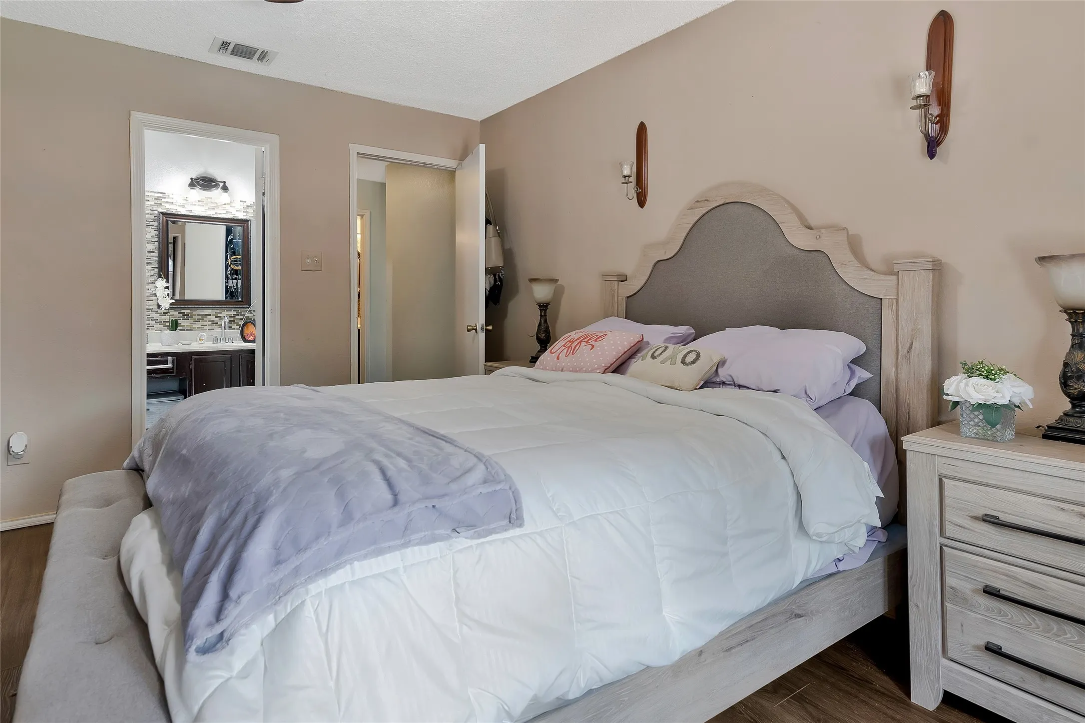 Bedroom with dark hardwood / wood-style flooring and ensuite bath