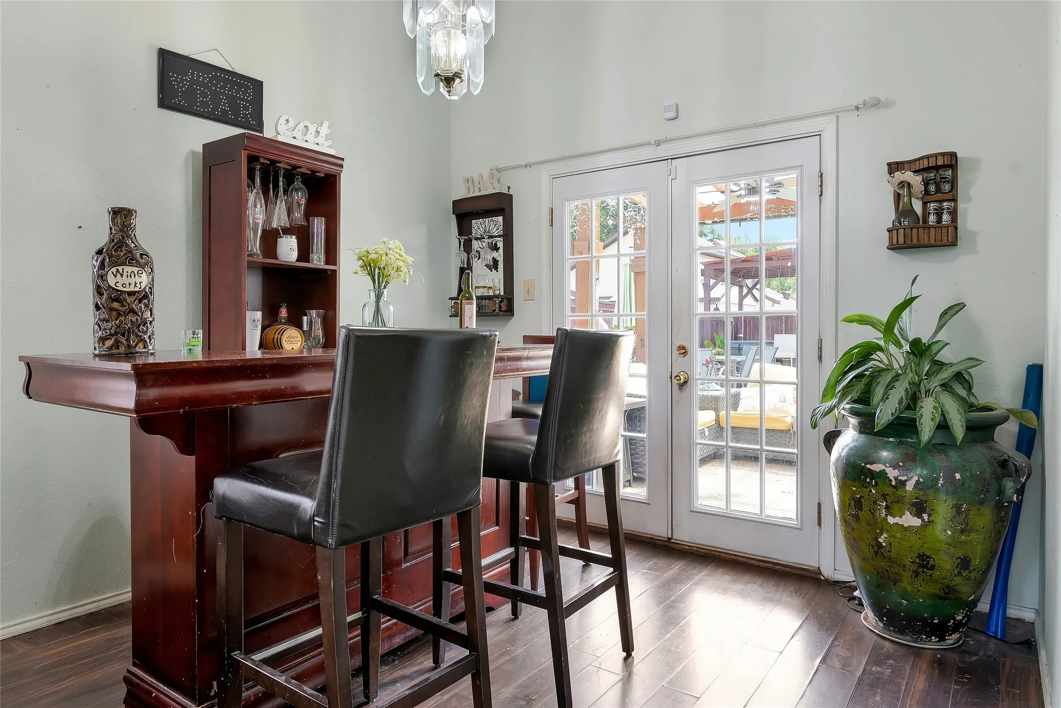 Bar with dark hardwood / wood-style floors, french doors, and a wealth of natural light