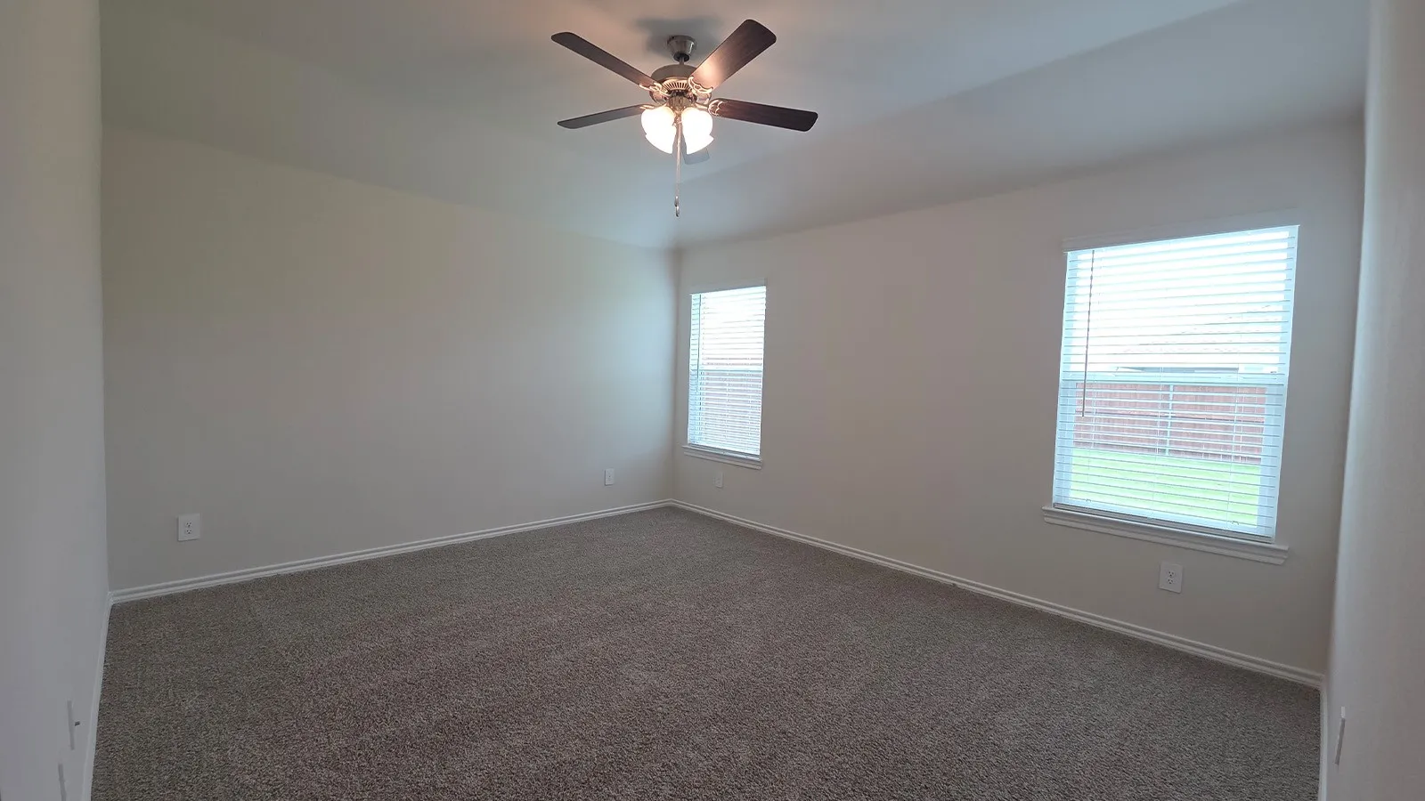Spacious room featuring neutral carpeting and light-colored walls