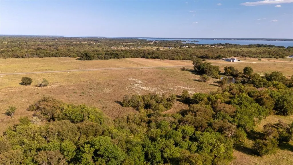 Expansive rural landscape featuring a mix of open fields and mature tree coverage