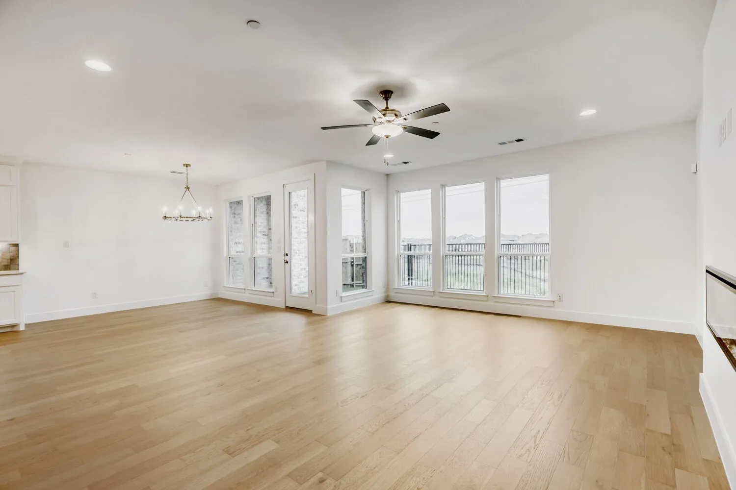 Spacious interior featuring light wood-finish flooring, recessed lighting, and a contemporary ceiling fan