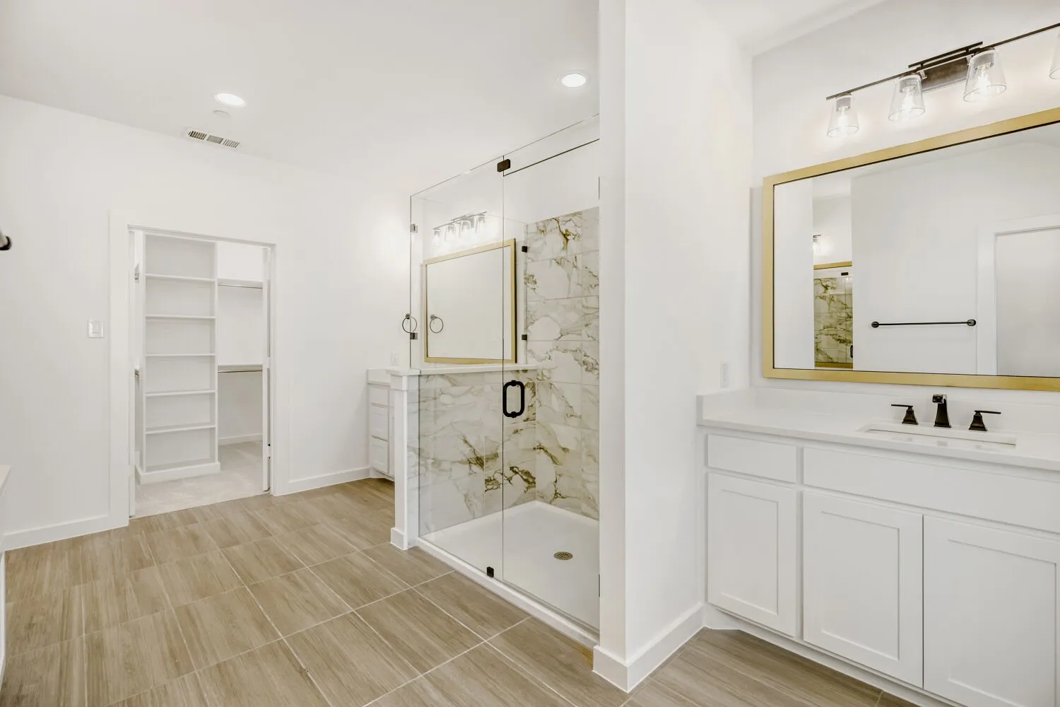 White bathroom featuring wood-finish tile flooring, a glass-enclosed shower with marble-look wall tile, and a white vanity with a quartz countertop