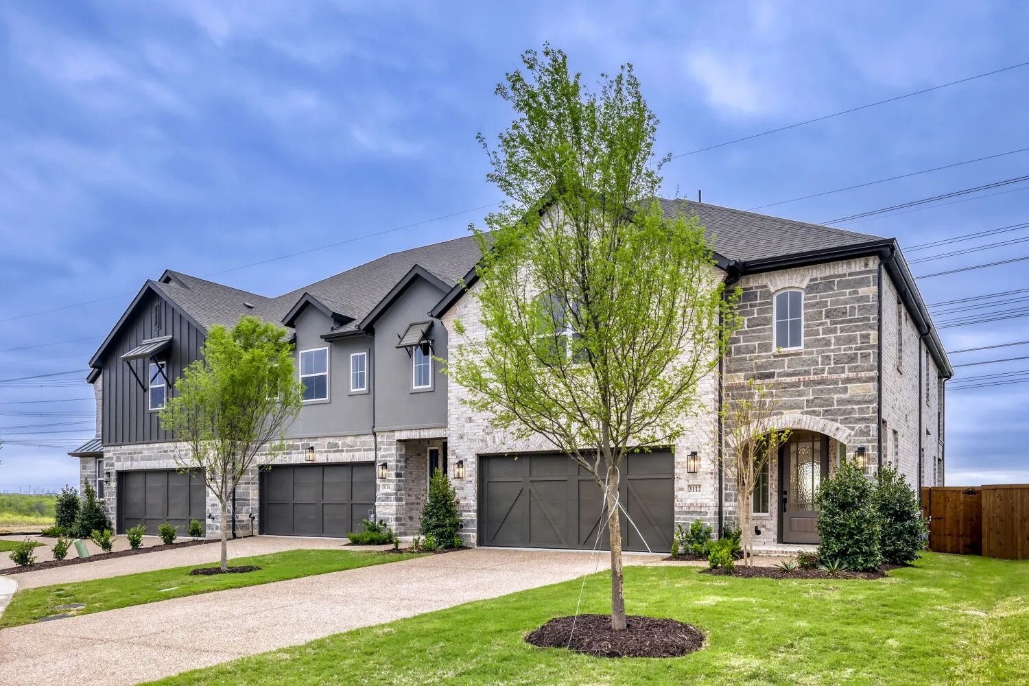 Stone and board-and-batten exterior featuring a dark asphalt shingle roof