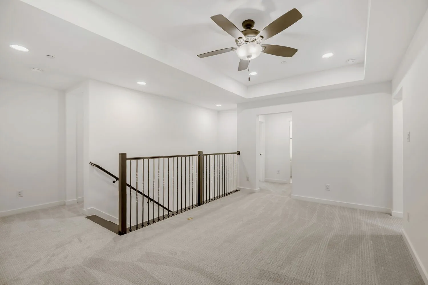 Upper-level space featuring light-toned carpeting, recessed lighting, and a ceiling fan