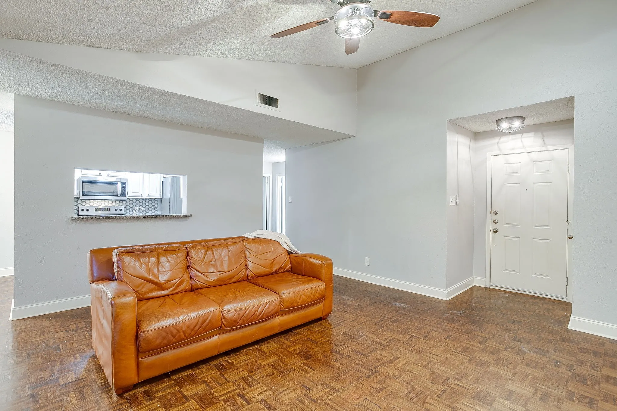 Living area with vaulted ceiling and wood-finish flooring
