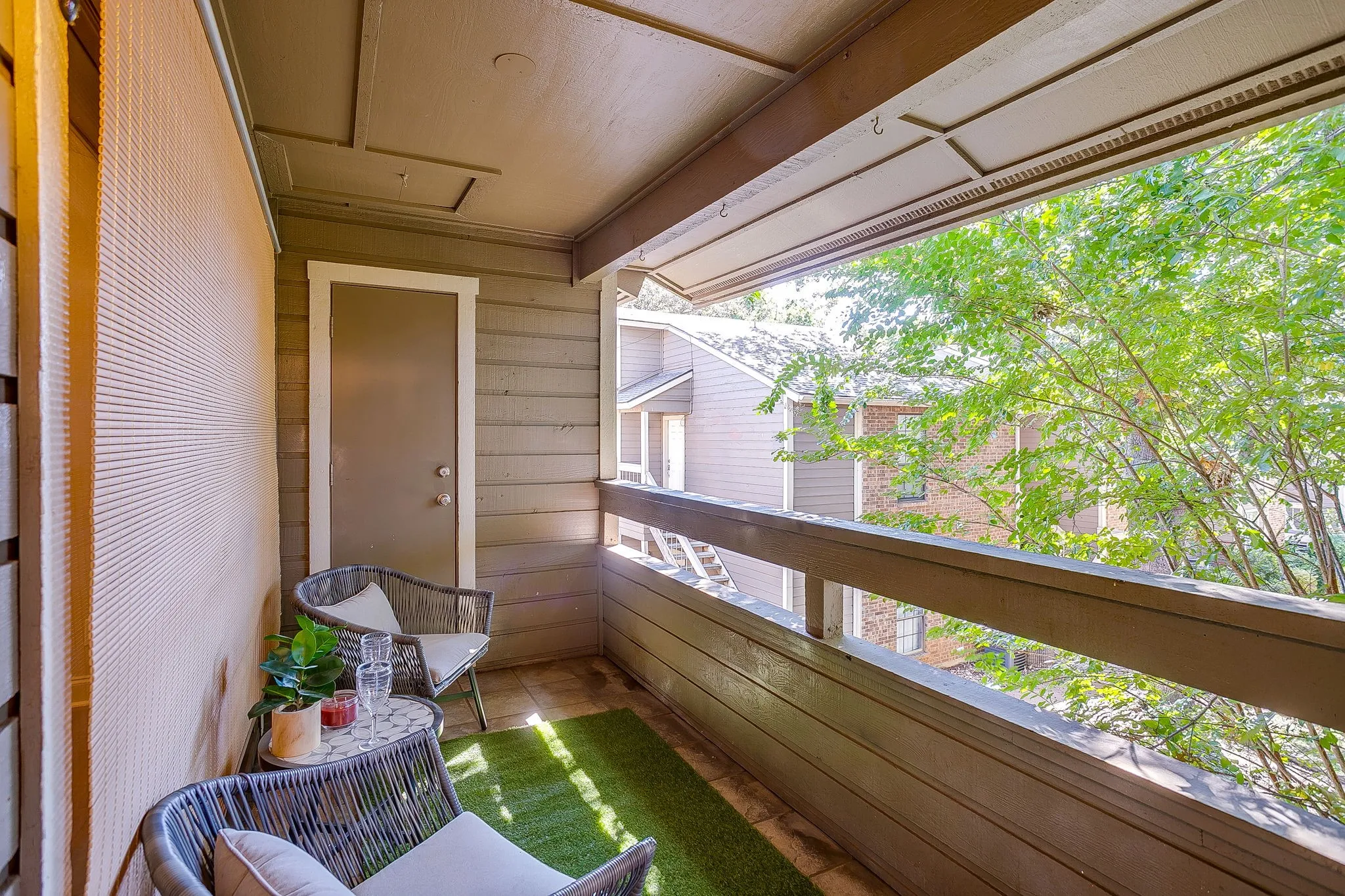 Private outdoor balcony featuring a privacy screen and a secure exterior door