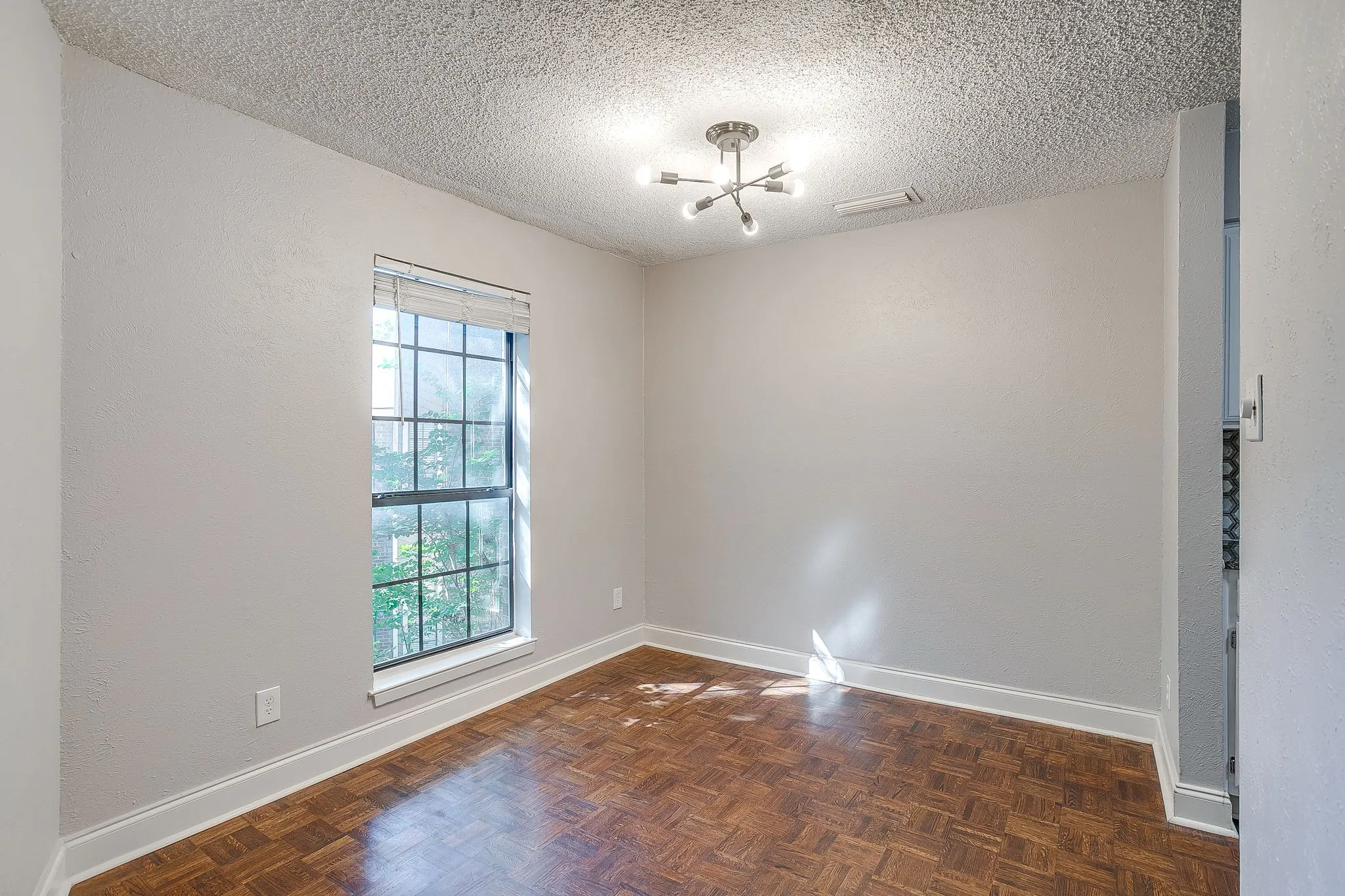 Hardwood parquet flooring with white baseboards