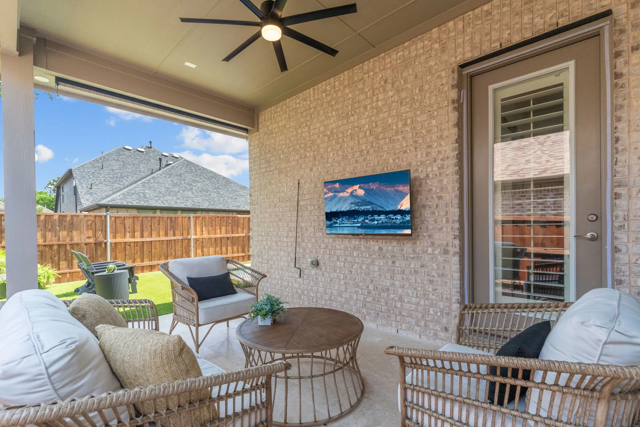 Access the covered patio from the living room. Sellers added the Fanimation outdoor ceiling fan + rolldown privacy shade.