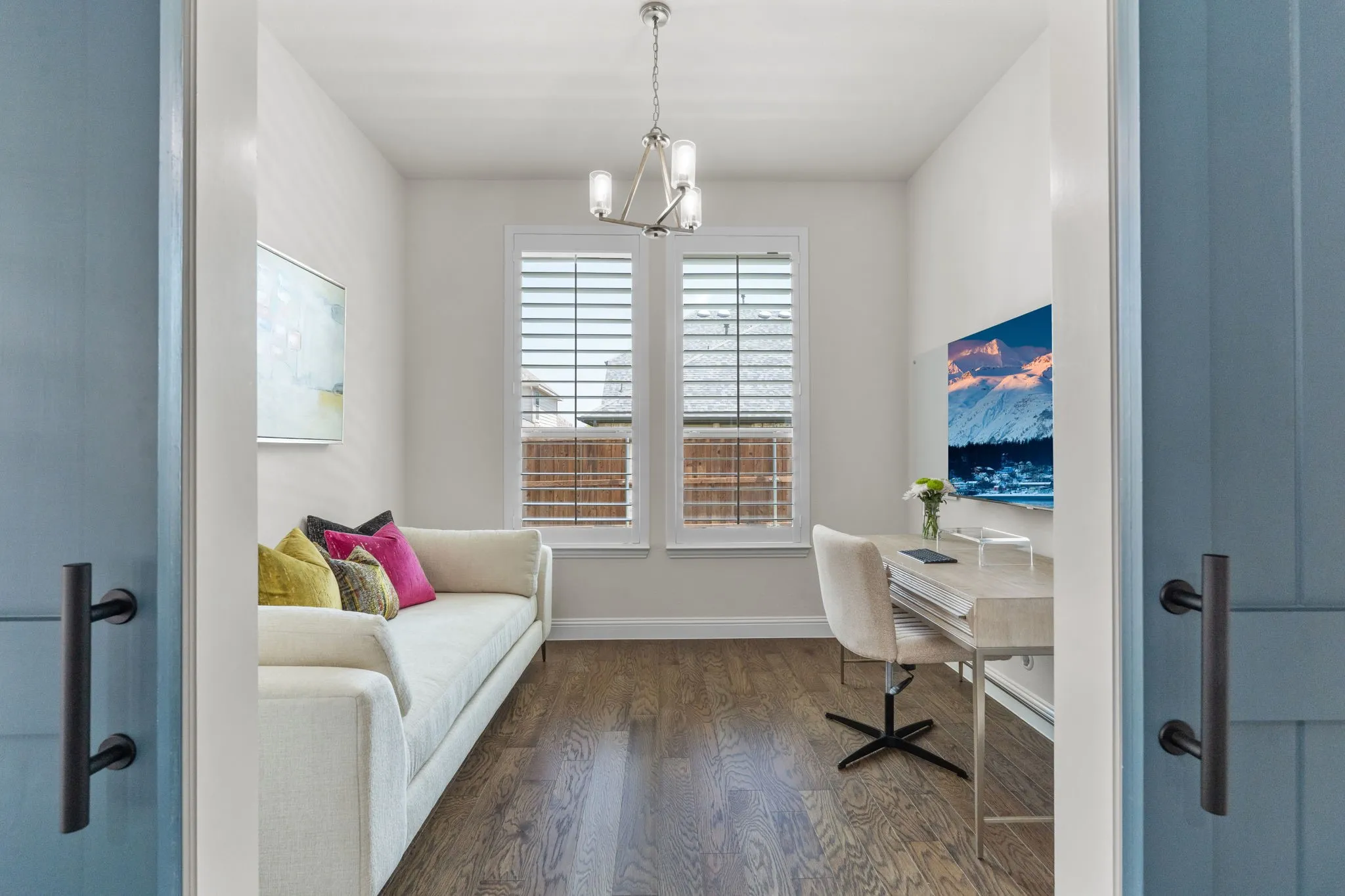 Custom barn doors create privacy for a home office, study area, or multipurpose room. Peek out to the swimming pool through the picture window.