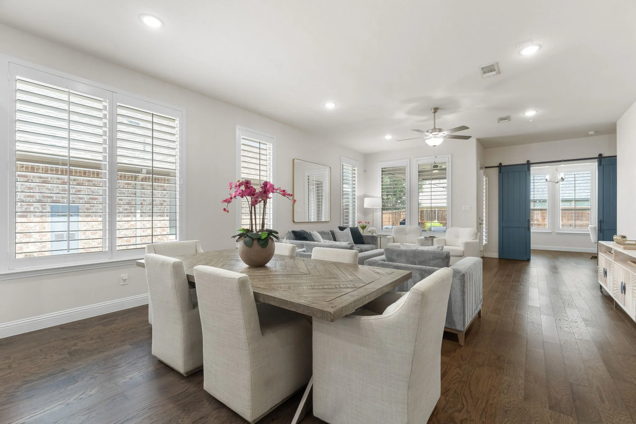 Abundant natural light from the wall of windows covered by plantation shutters throughout the home.