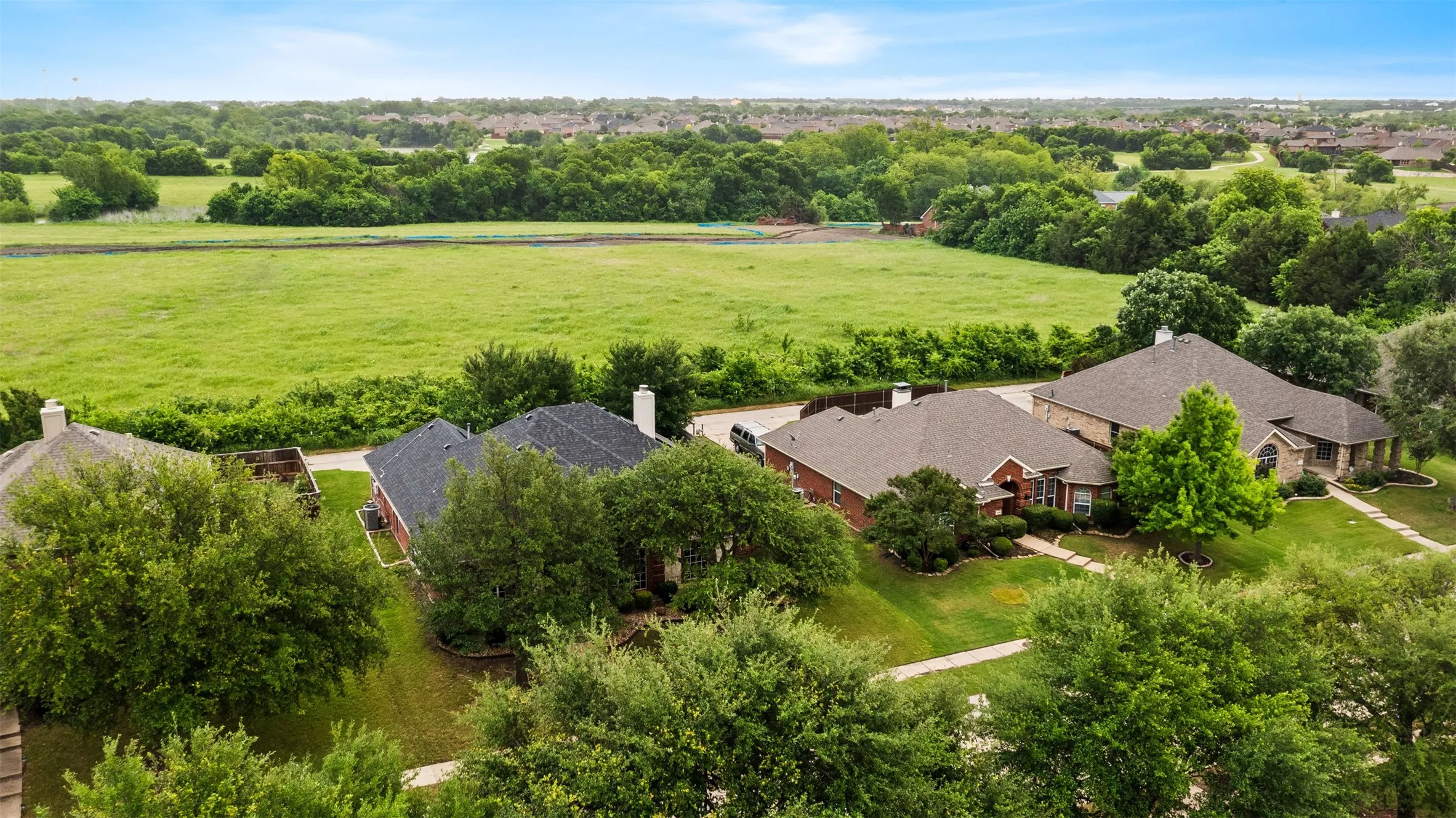 Aerial perspective showcasing multiple properties with expansive green spaces