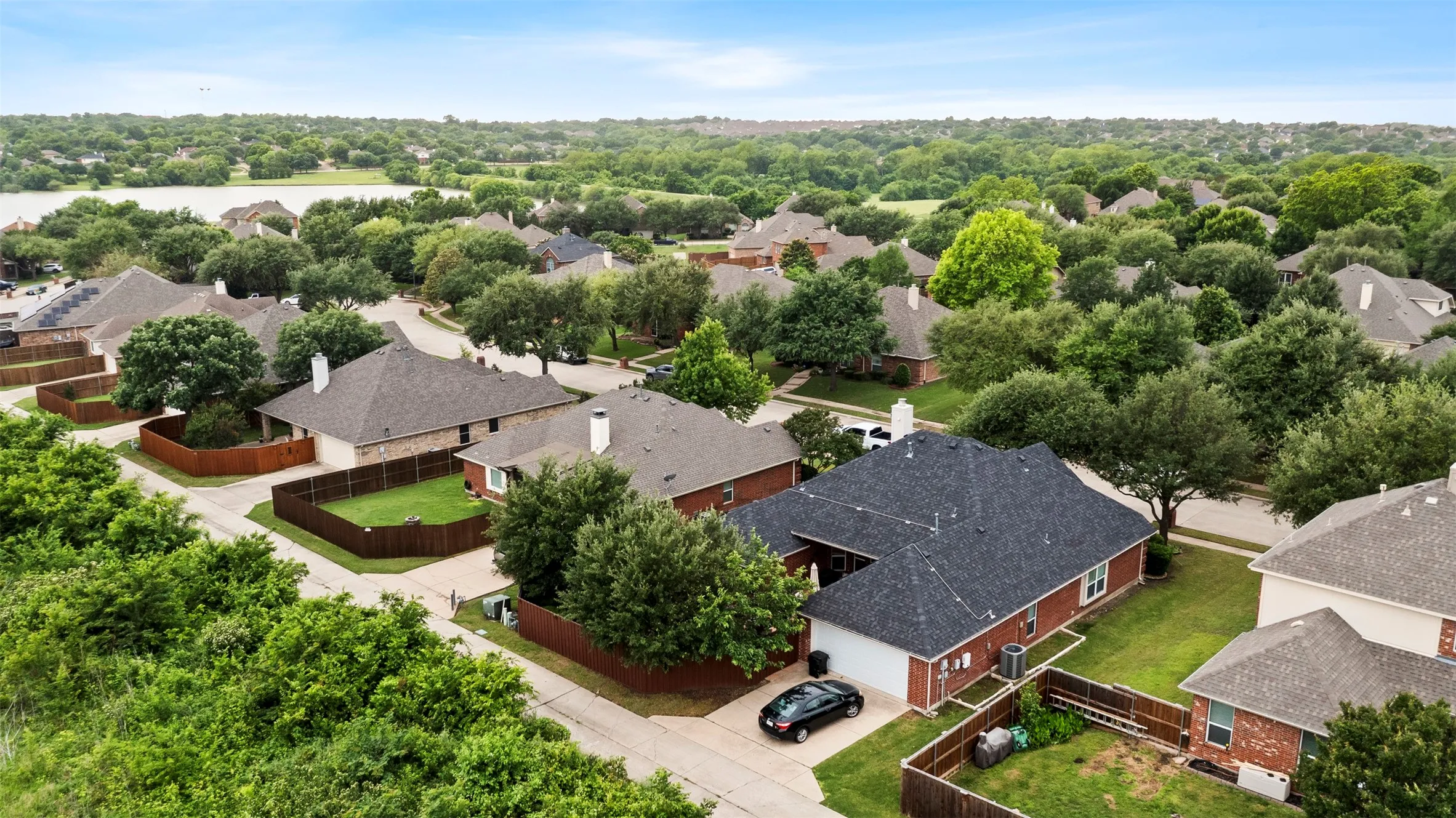 Aerial perspective showcasing a residential neighborhood with a distant body of water