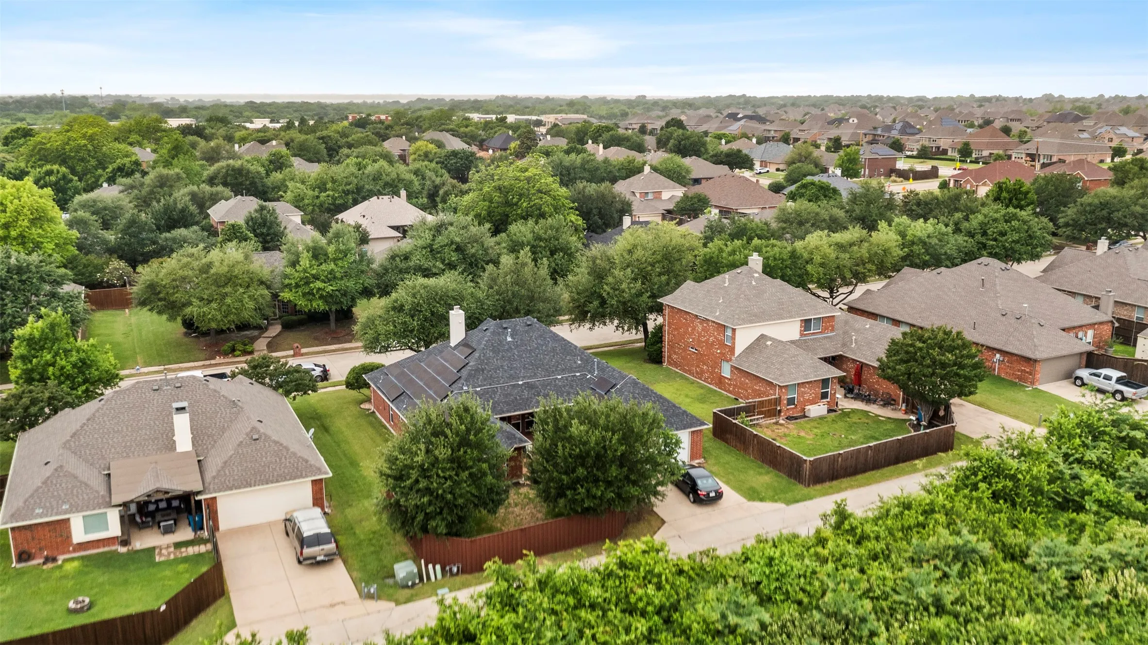 Aerial perspective showcasing a residential neighborhood with mature tree coverage