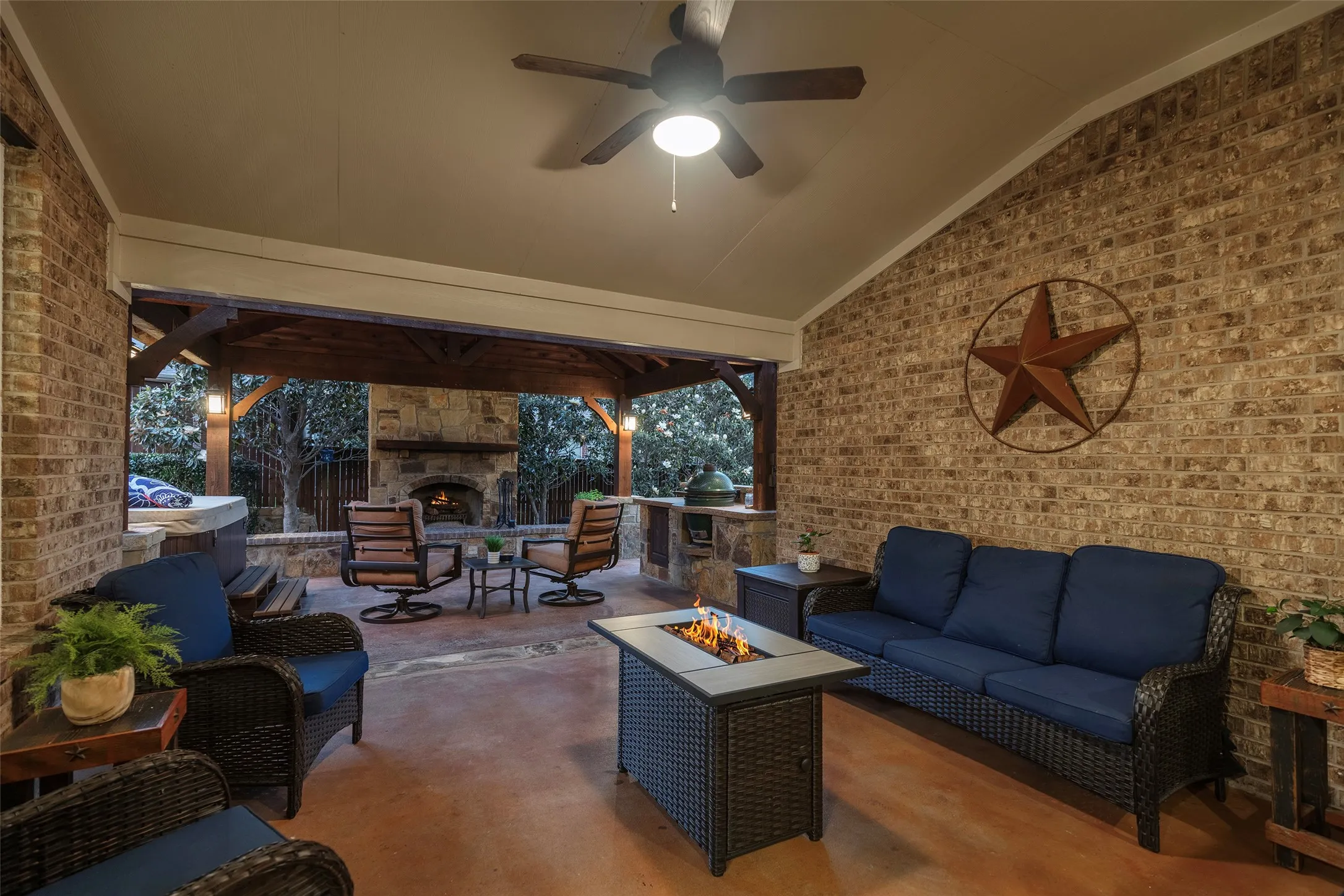 Covered outdoor living area designed for year-round entertaining beside the fireplace.