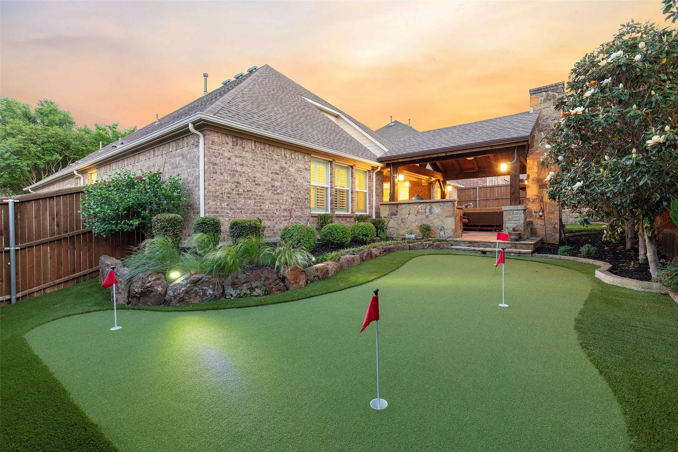Professionally designed putting green surrounded by mature landscaping and resort-style outdoor amenities.