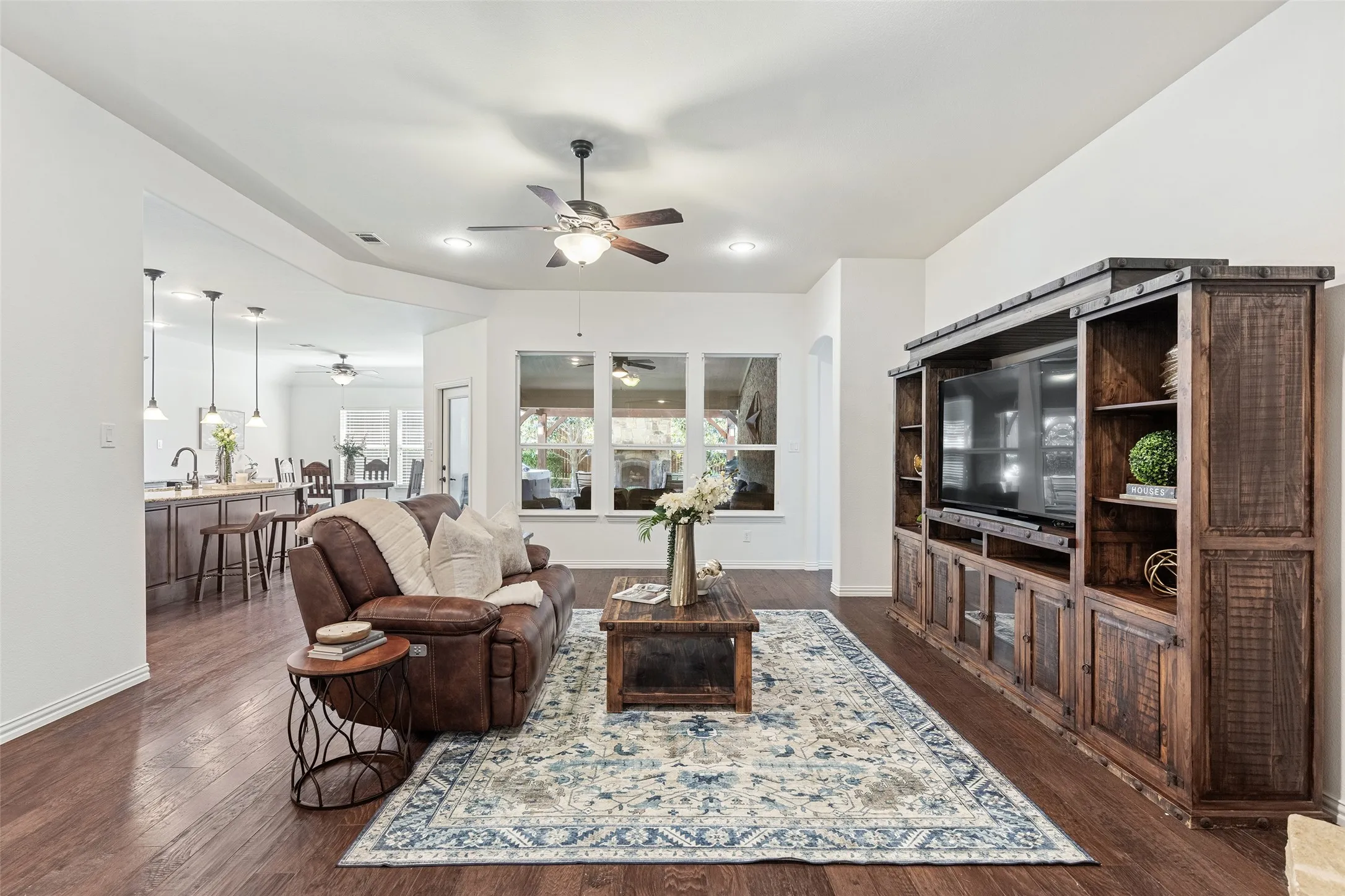 Spacious family room centered around custom rustic cabinetry and backyard views.