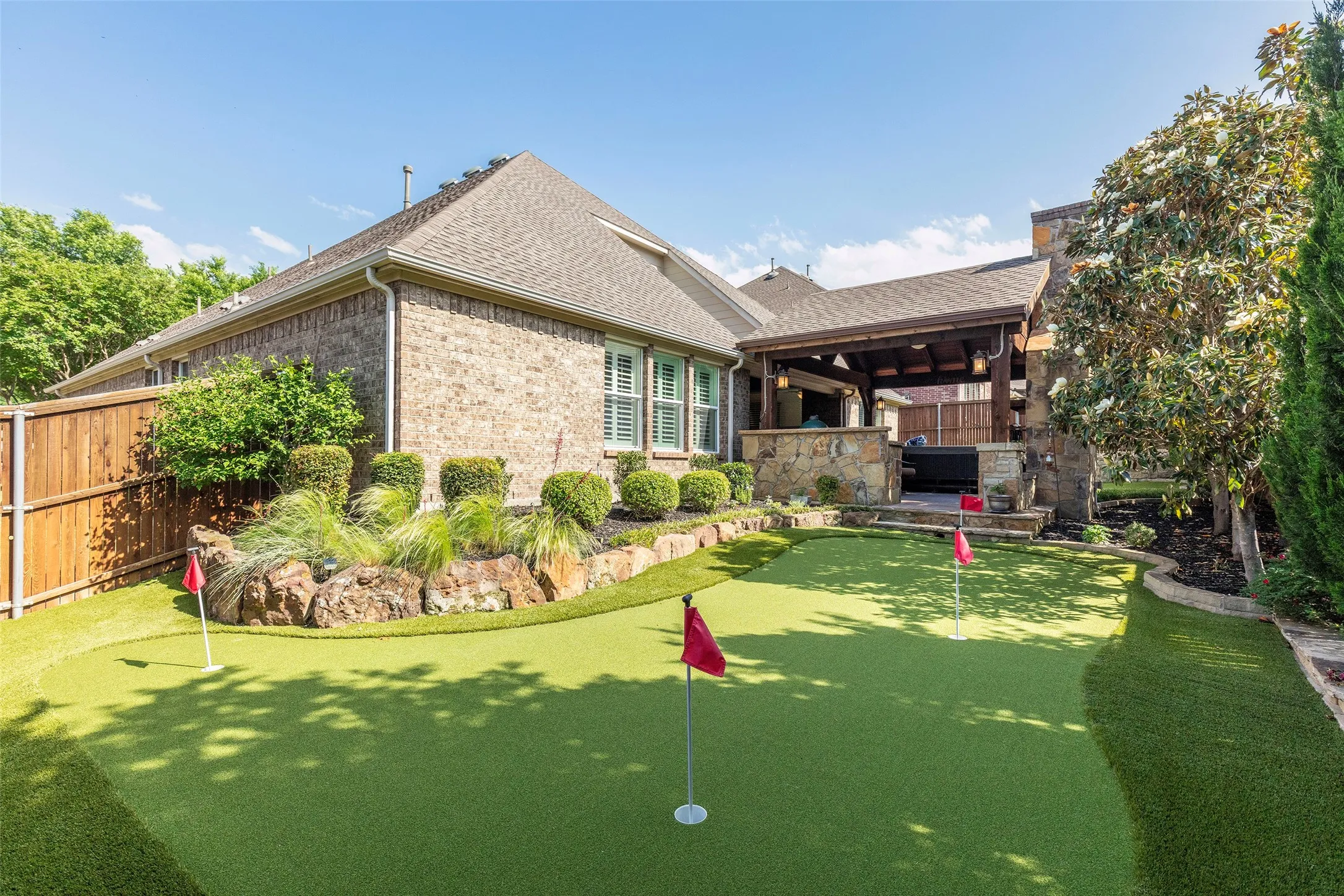 Private backyard retreat featuring a relaxing hot tub, professionally designed putting green, and beautifully landscaped surroundings for everyday resort-style living.