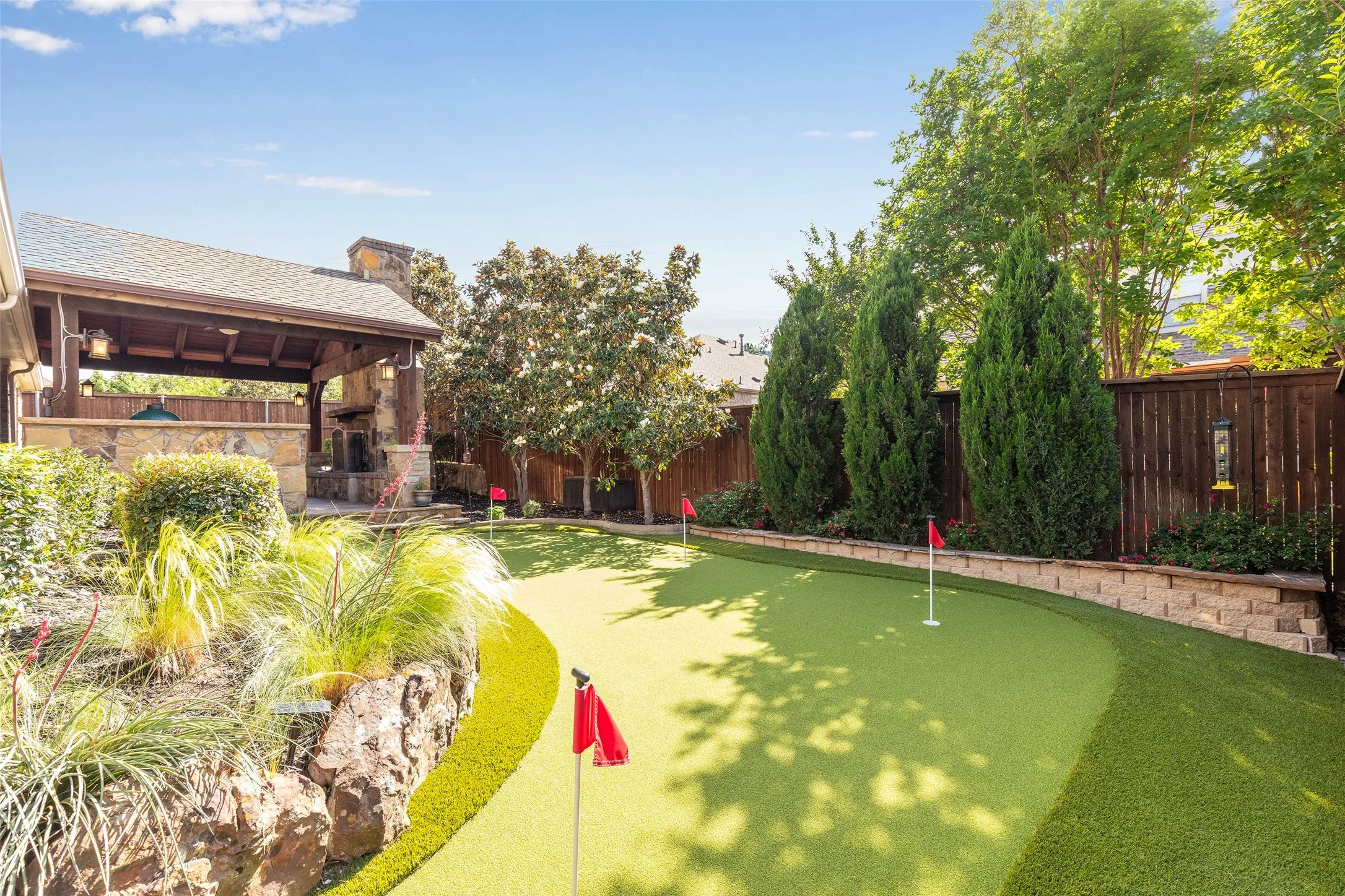 Resort-style backyard with custom putting green and lush surrounding landscape.