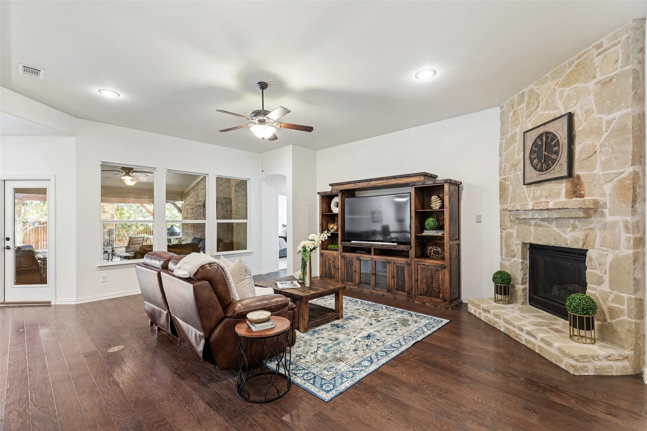 Inviting gathering space featuring a stone fireplace and oversized media wall.