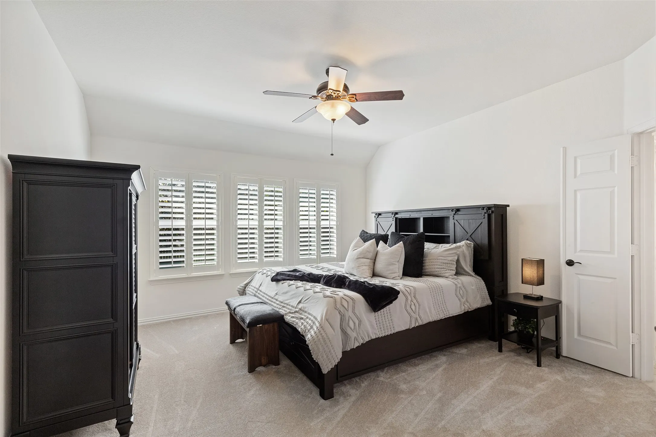 Peaceful primary retreat with plantation shutters and generous natural light.
