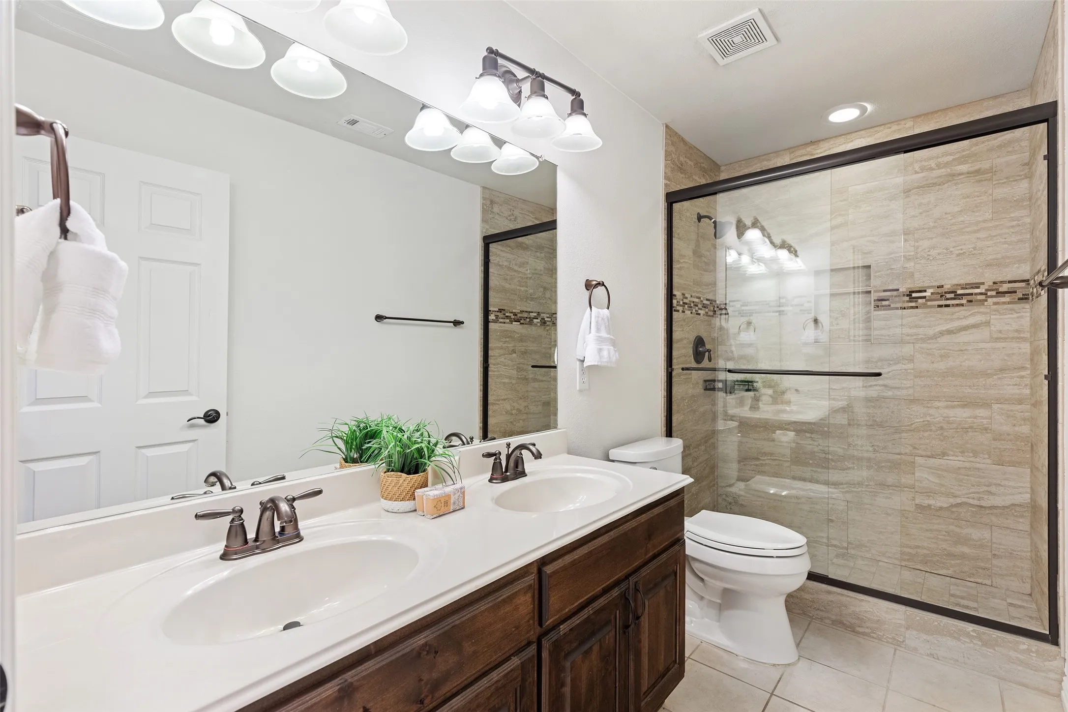 Stylish full bath with oversized vanity and updated tile surround.
