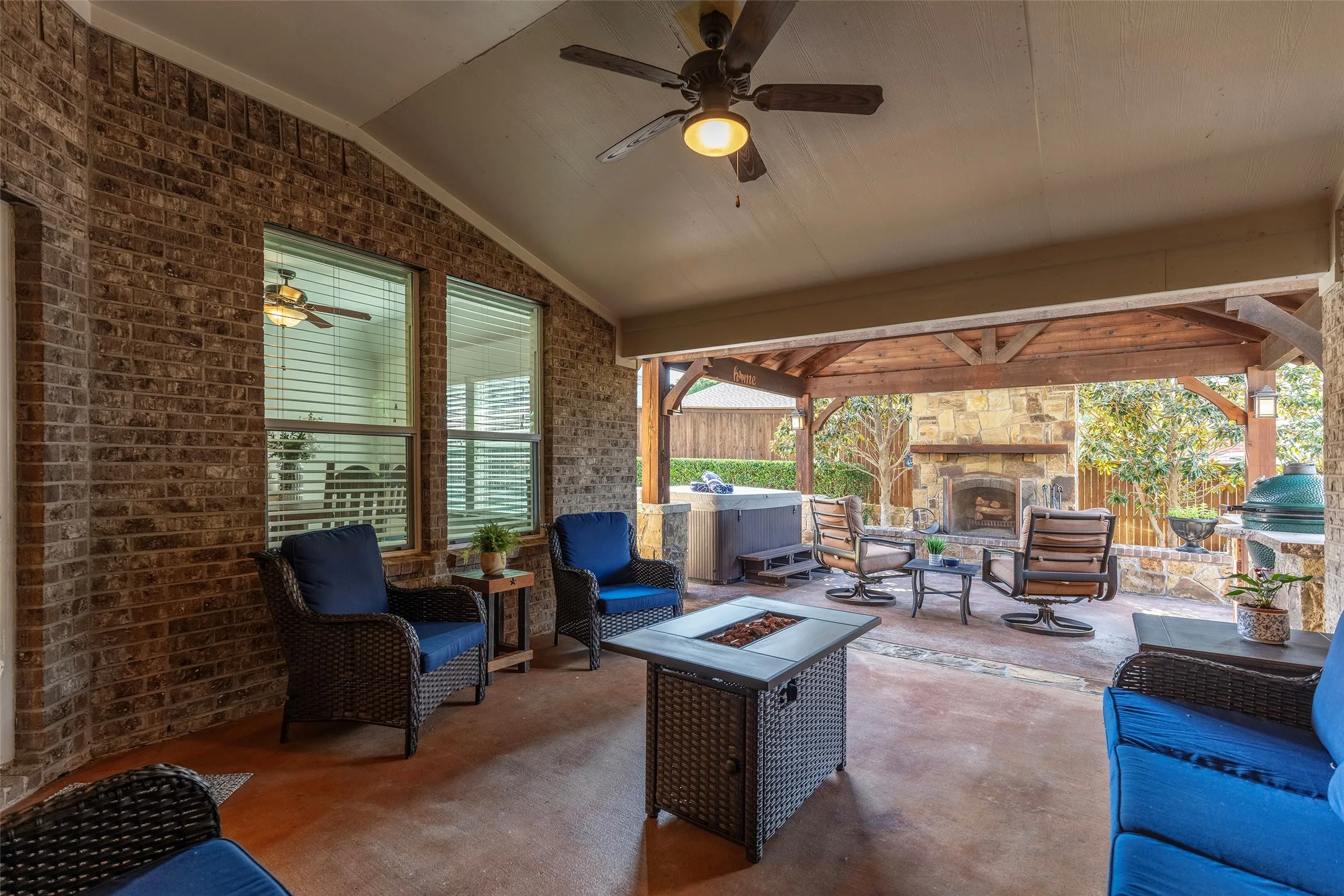Covered outdoor living area designed for year-round entertaining beside the fireplace and hot tub.