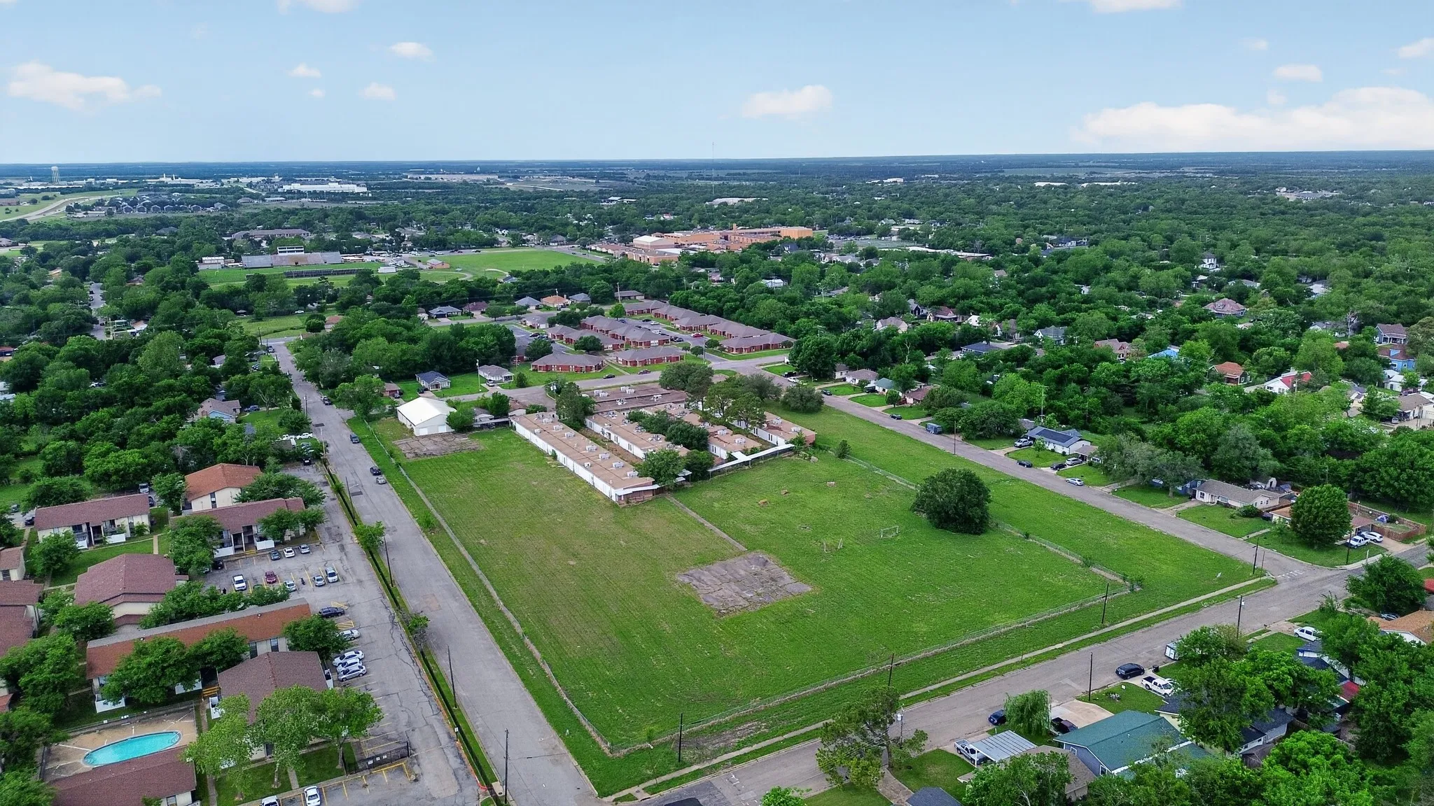 Expansive green space featuring large open fields and scattered mature trees