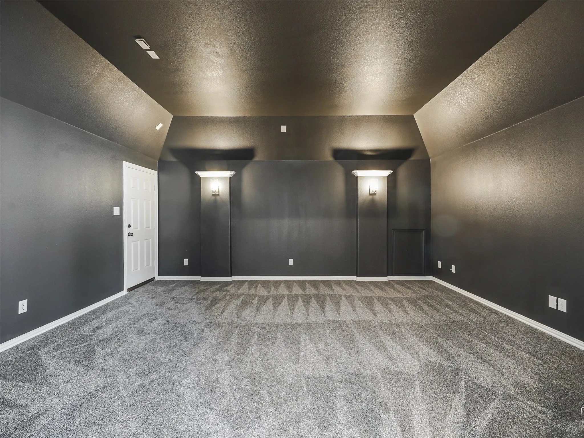 Access to Balcony pacious interior room featuring dark gray walls and a geometric pattern carpet