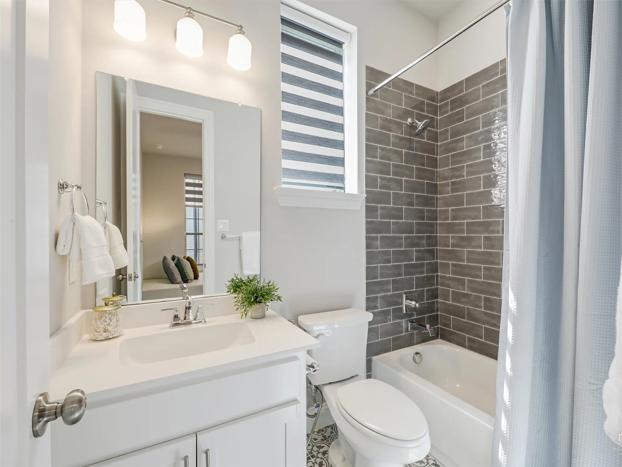 Bathroom featuring a white vanity with an integrated sink, chrome faucet, and overhead three-bulb vanity light fixture