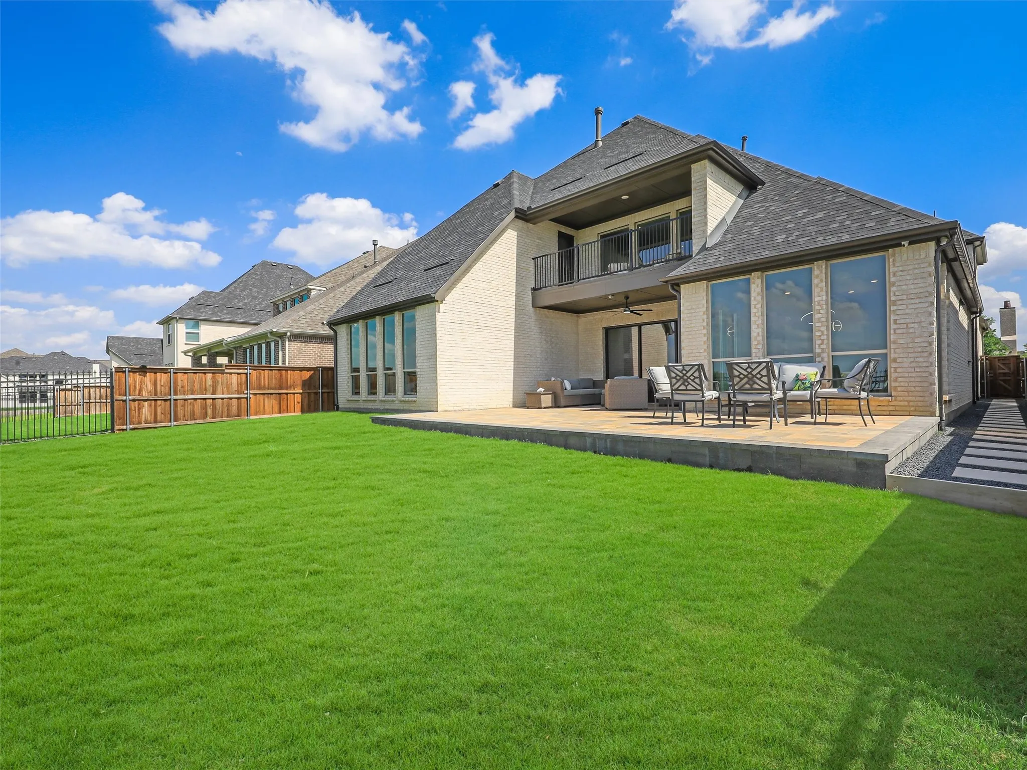 Expansive manicured lawn with a spacious paver patio