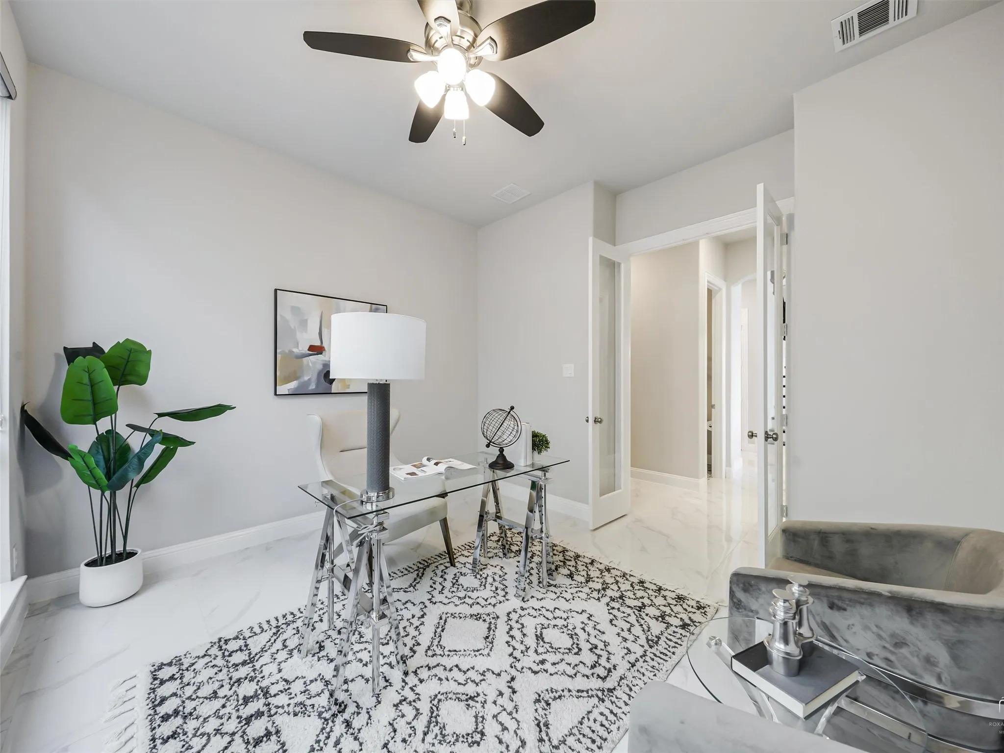 Bright interior space featuring white walls, a ceiling fan with integrated lighting, and white tile flooring