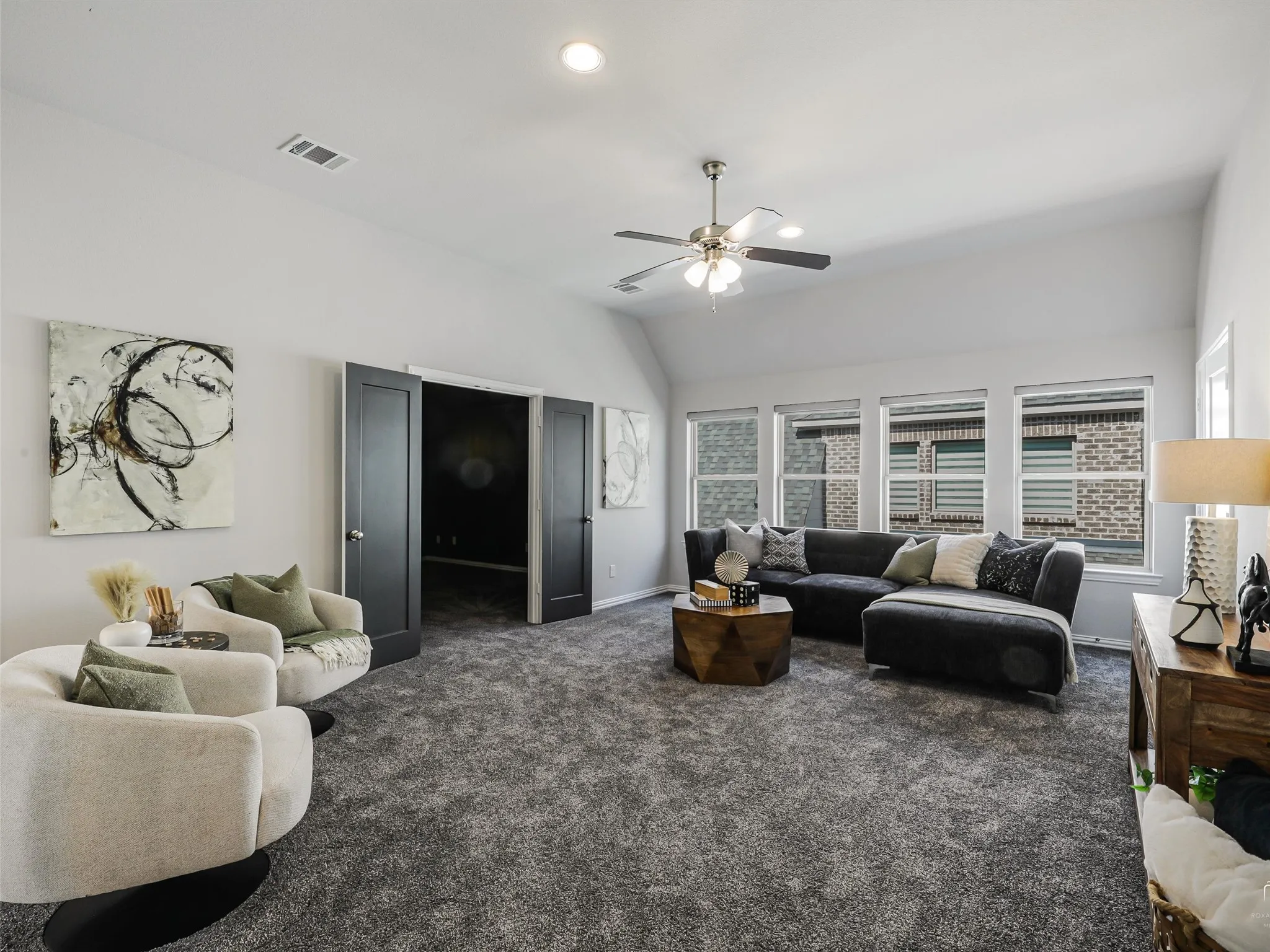 Spacious room featuring vaulted ceilings, recessed lighting, and a ceiling fan