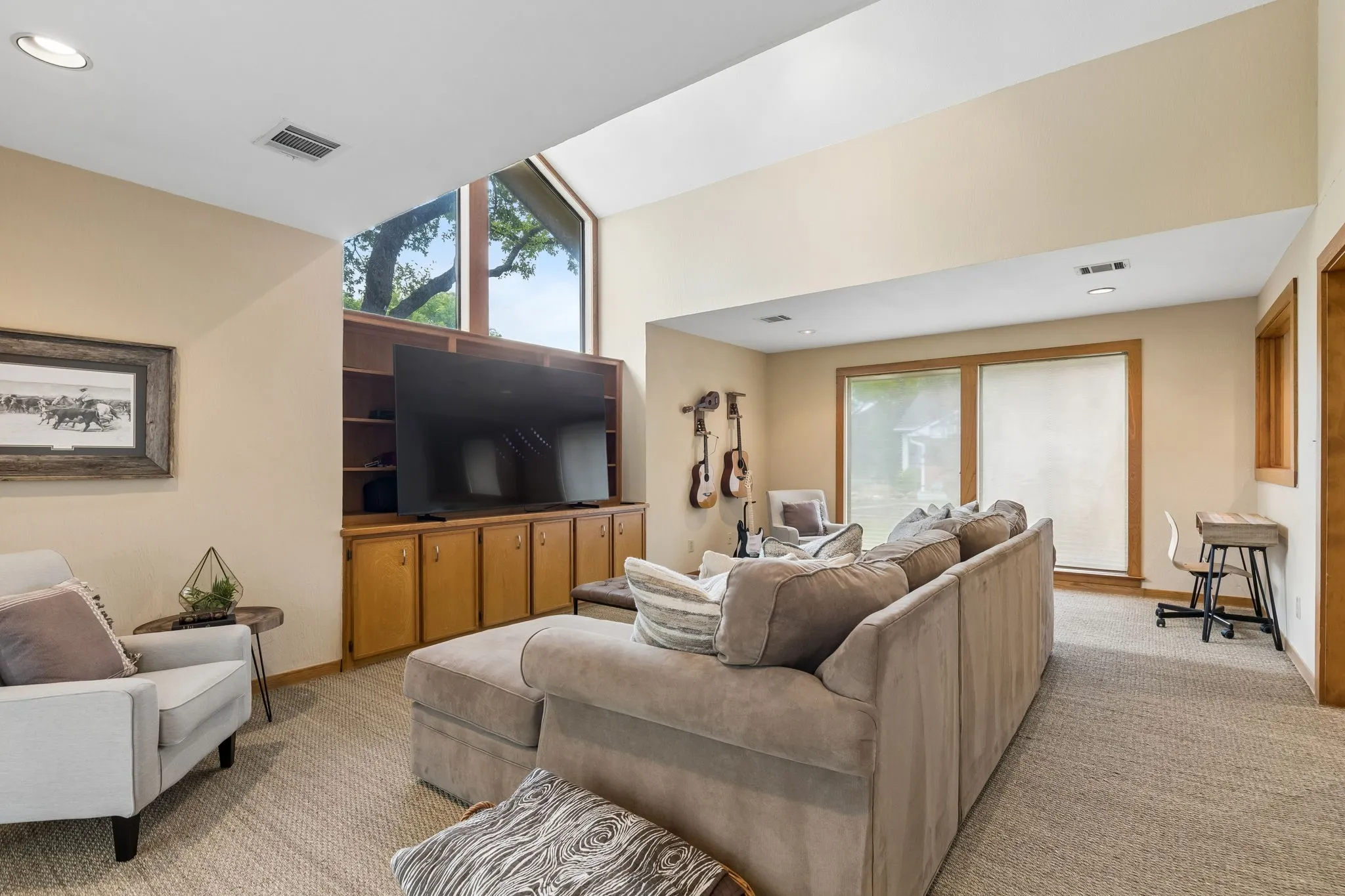 Vaulted ceiling living area featuring a built-in entertainment center, upper transom windows, recessed lighting, and carpet flooring