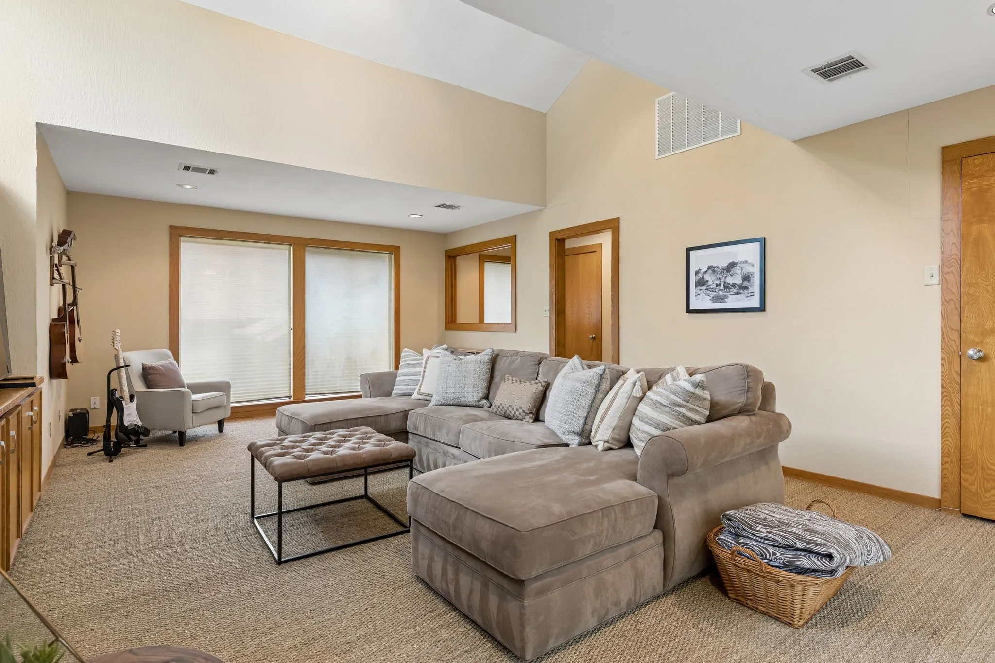 Spacious interior with vaulted ceilings, recessed lighting, and large windows providing natural illumination