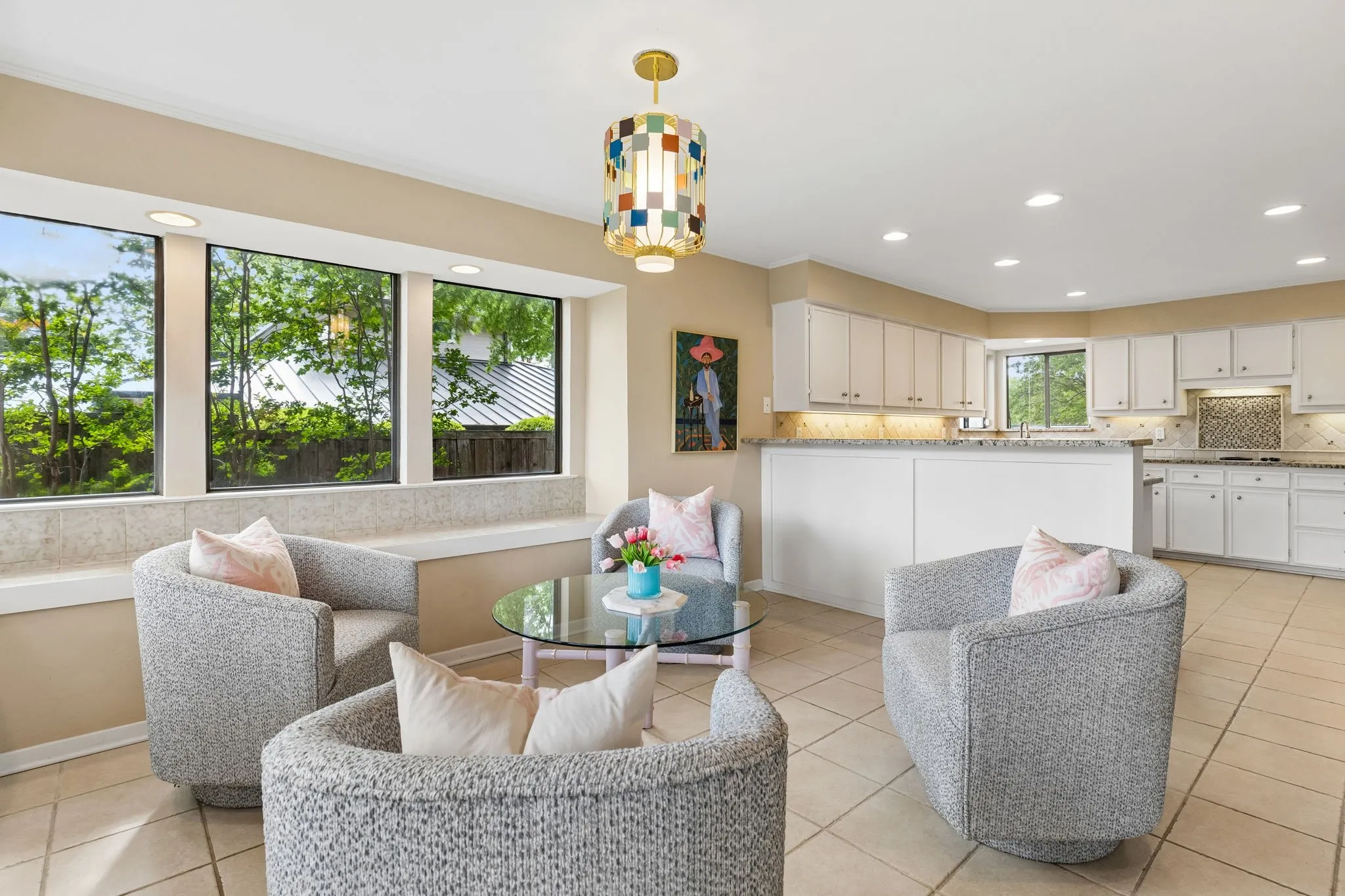Bright interior space featuring a wall of three large windows, a built-in window bench, and recessed lighting