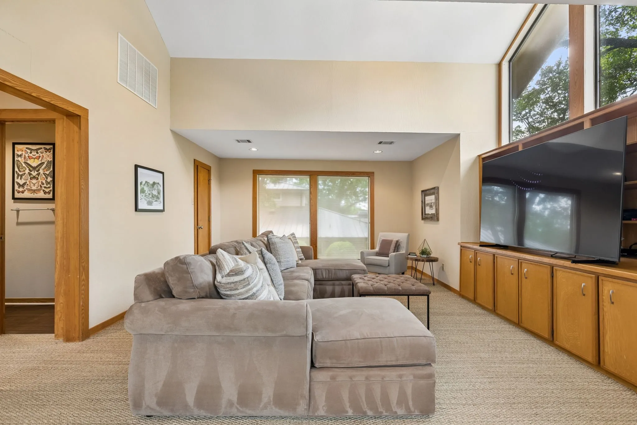 Vaulted ceilings with high windows, built-in cabinetry, recessed lighting, and wood-finish door frames