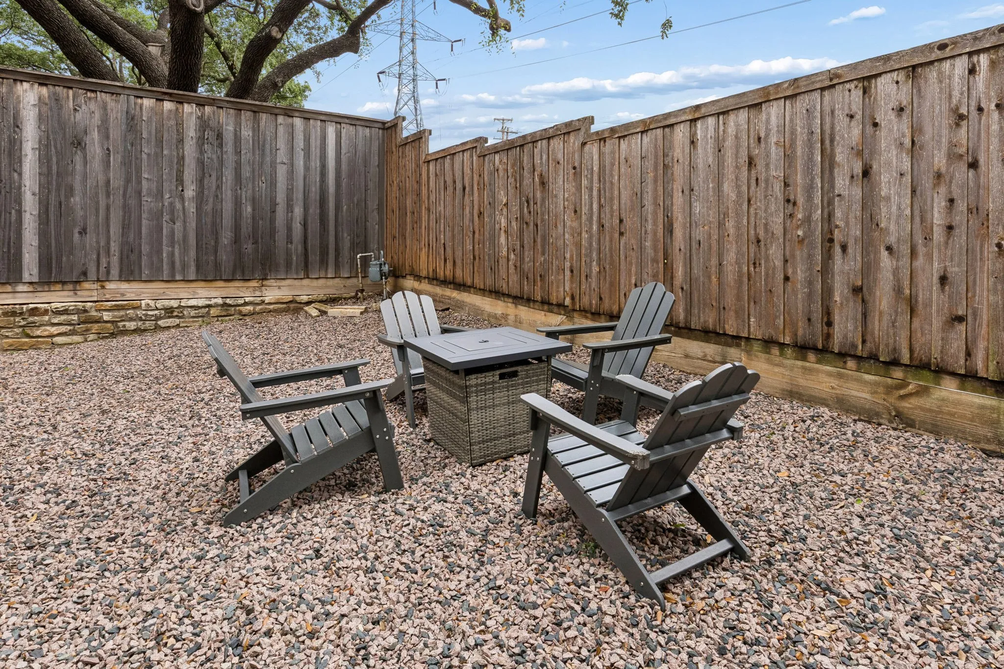 Private outdoor space with gravel ground cover, surrounded by wood privacy fencing