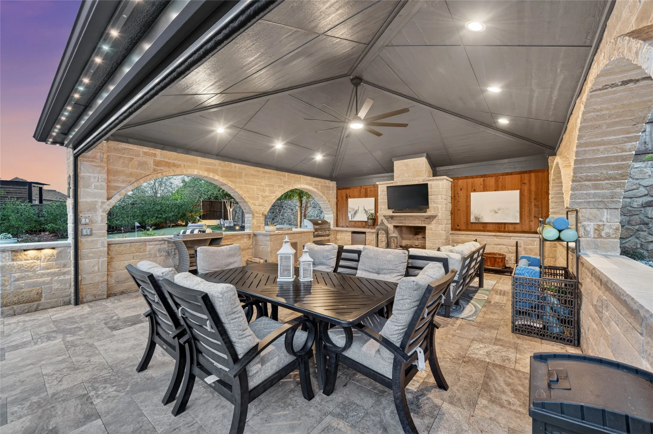 The oversized cabana is an entertainer’s dream, complete with a wood-burning fireplace, outdoor kitchen, and remote-controlled screens for year-round comfort.