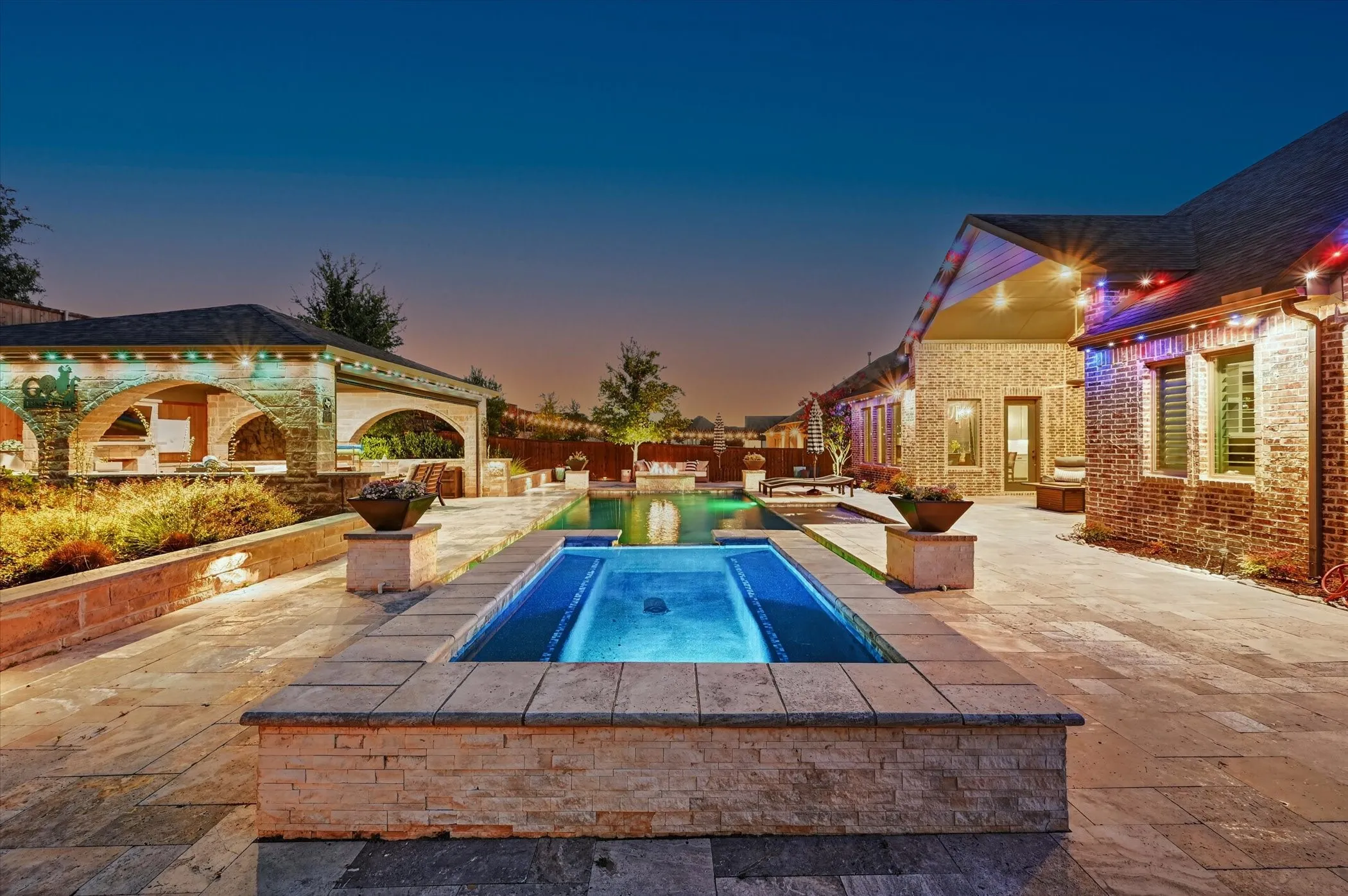 Enjoy a heated PebbleTec pool and spa, fire pit, silver travertine decking, putting green, lush landscaping with full irrigation, and low-maintenance turf.