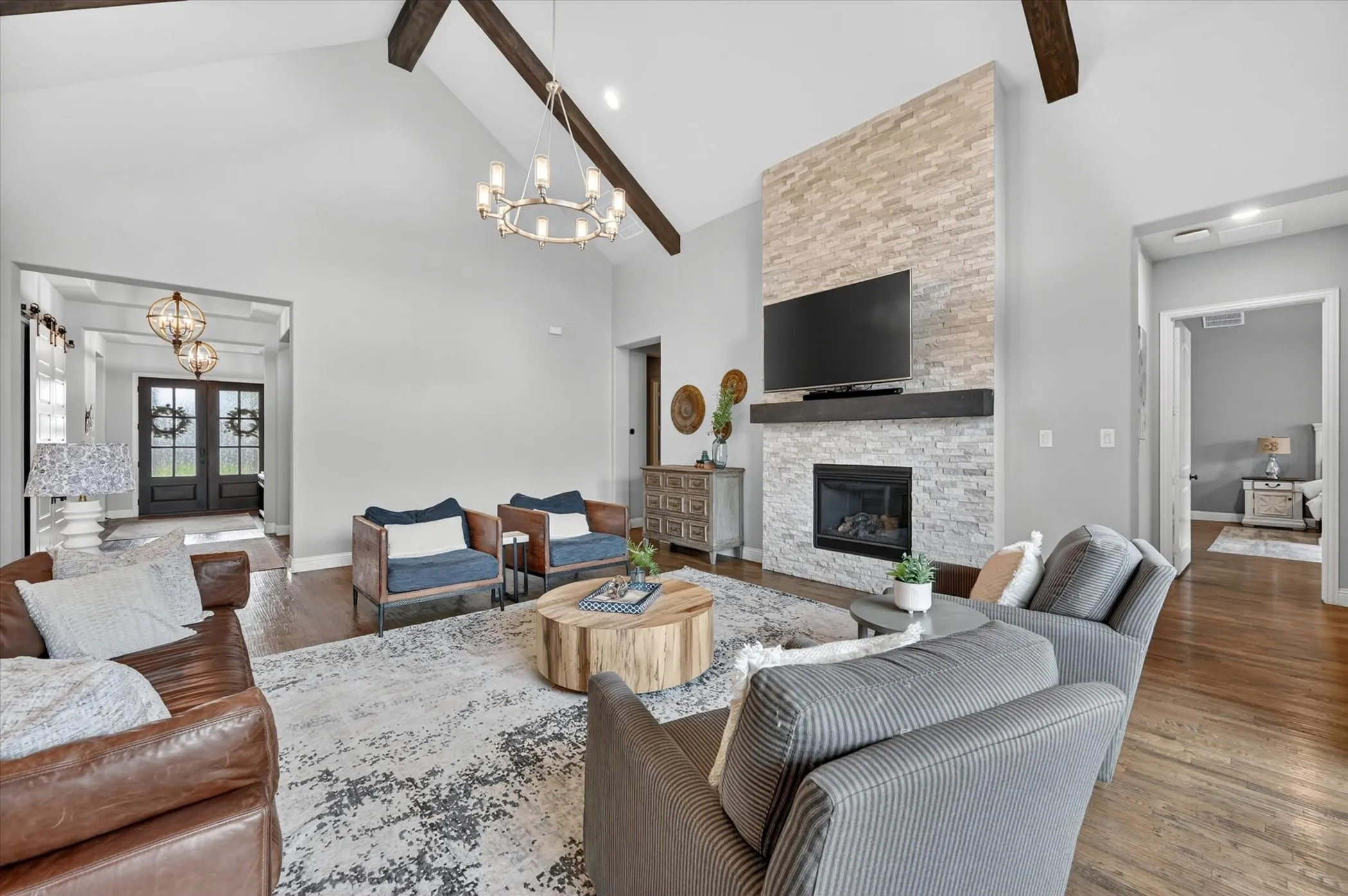 This spacious single-story is filled with elevated details—soaring wood-beamed ceilings, hand-scraped hardwood floors, plantation shutters, designer lighting, and a dramatic floor-to-ceiling stacked stone fireplace.