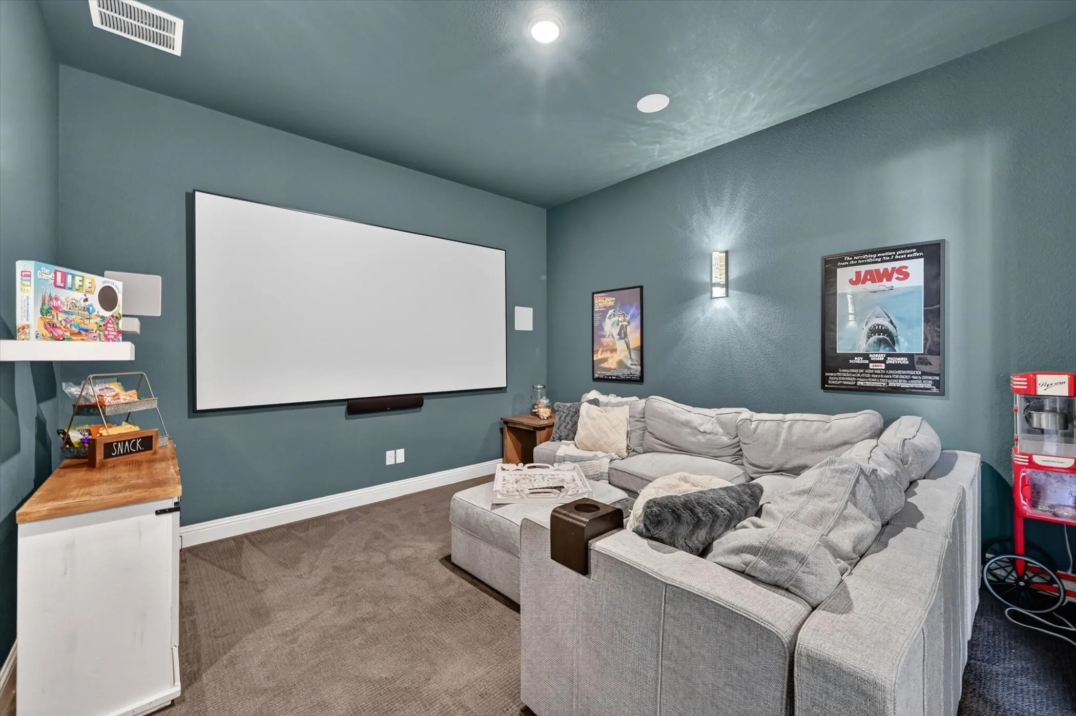 The bar area and fully equipped media room—complete with sliding barn doors, projector, screen, and built-in speakers—set the stage for unforgettable gatherings.