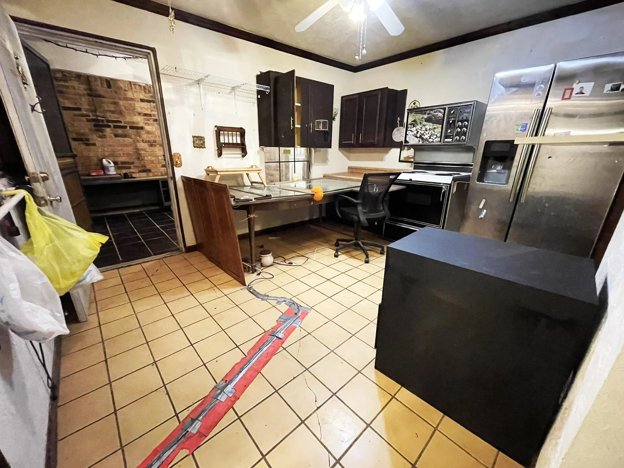 Kitchen area featuring tile flooring, dark wood cabinetry, and stainless steel refrigeration units